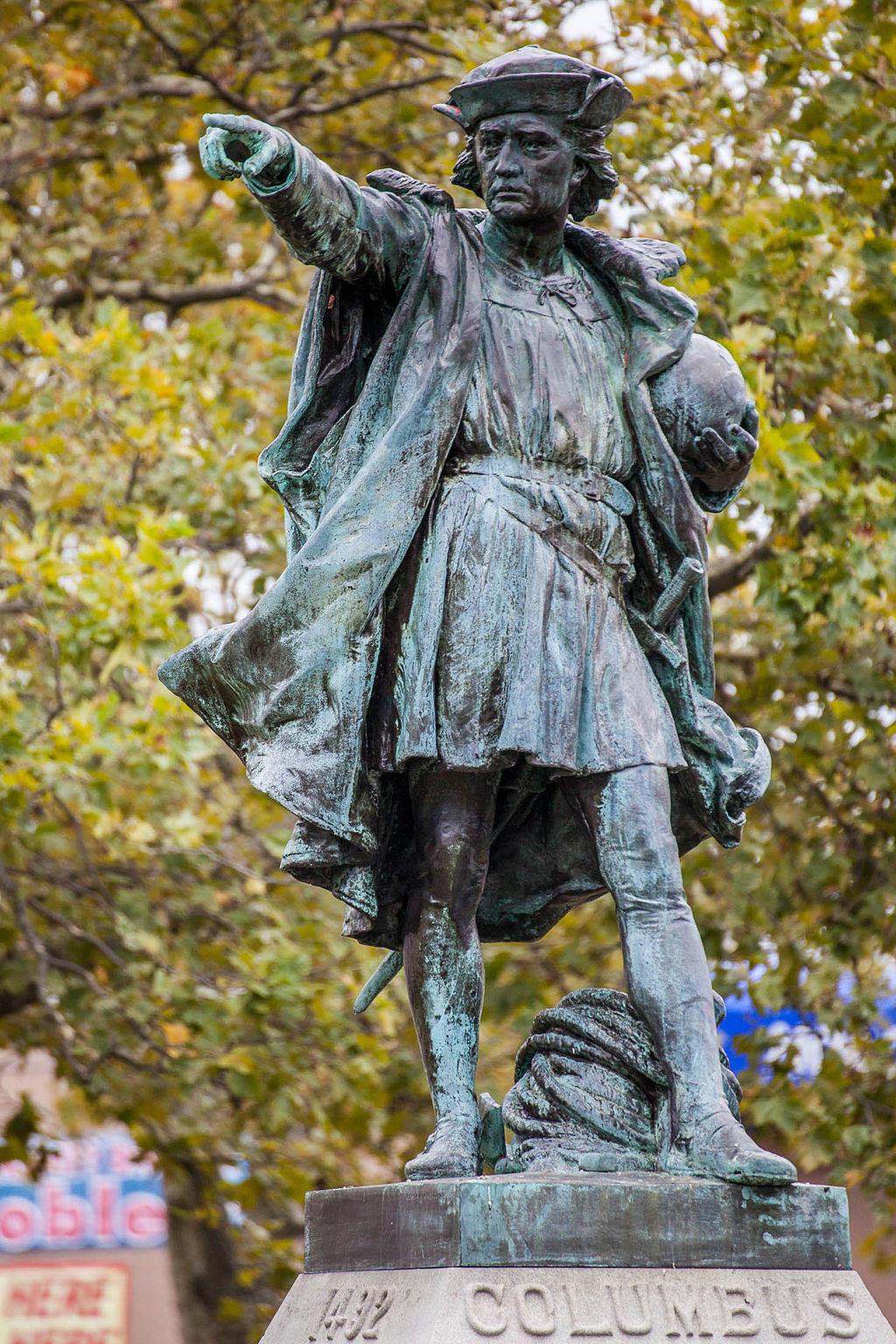 A statue of Christopher Columbus in a park.
