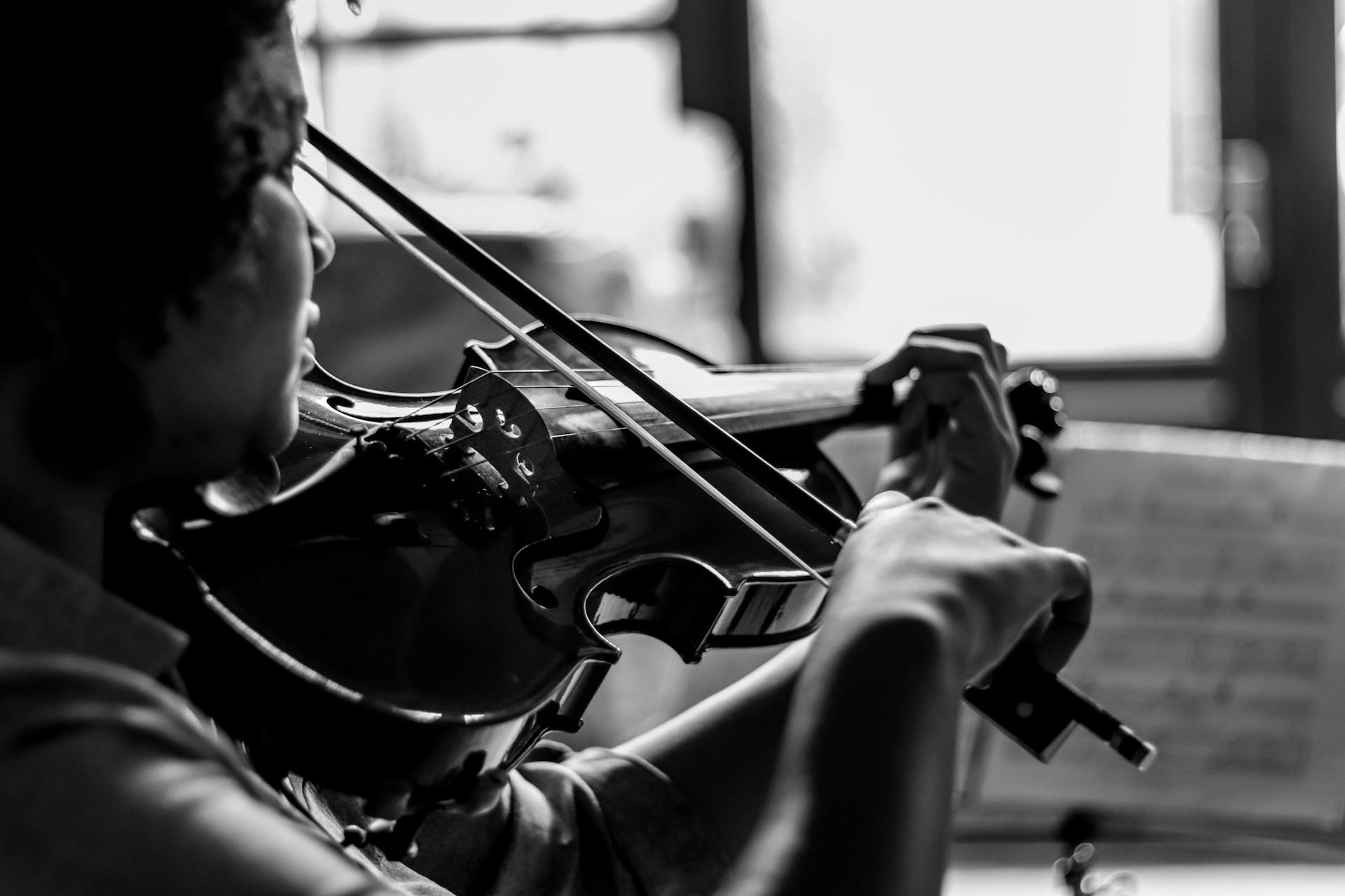 A grayscale photo of a woman playing the violin.