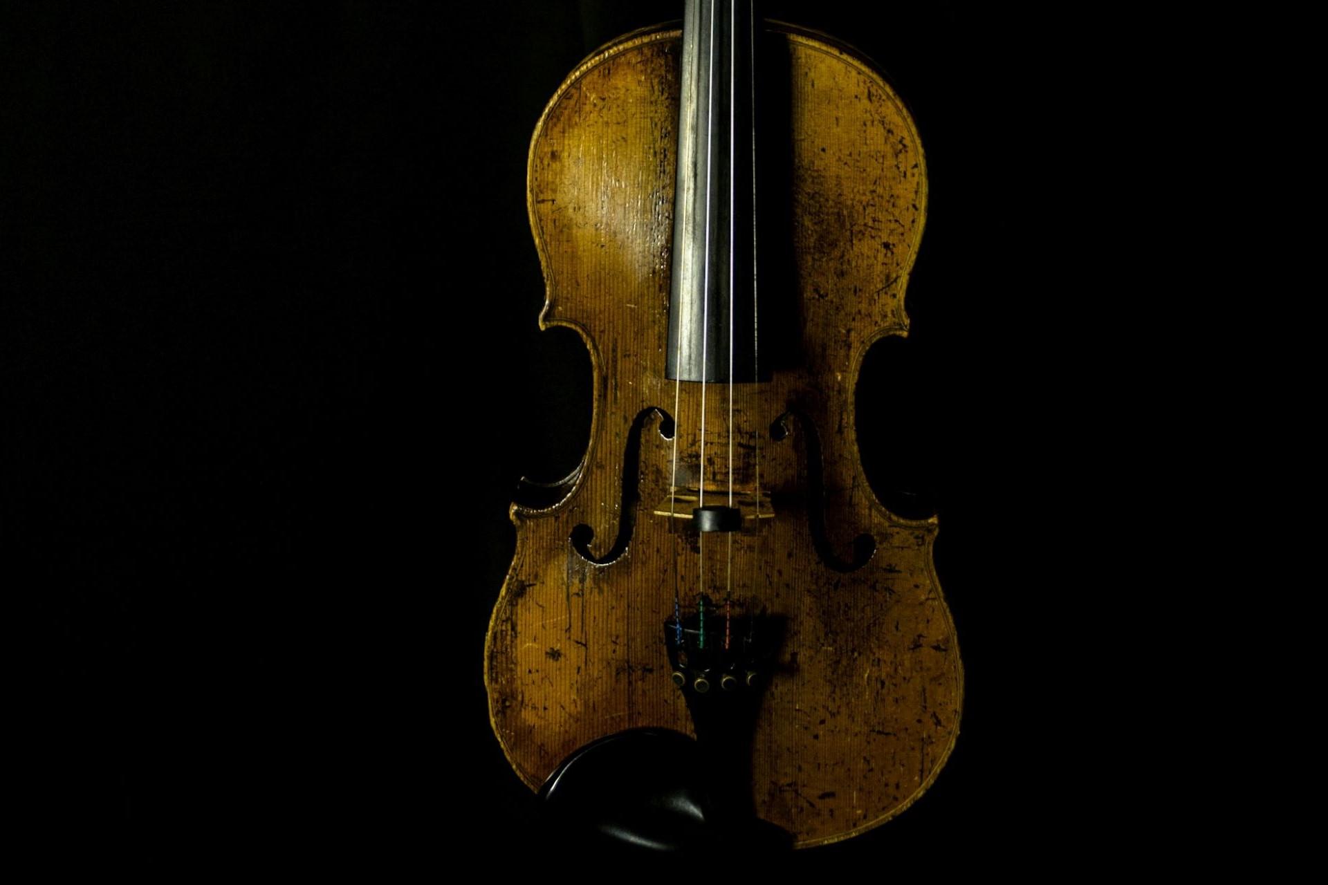 A closeup of a yellowed violin.