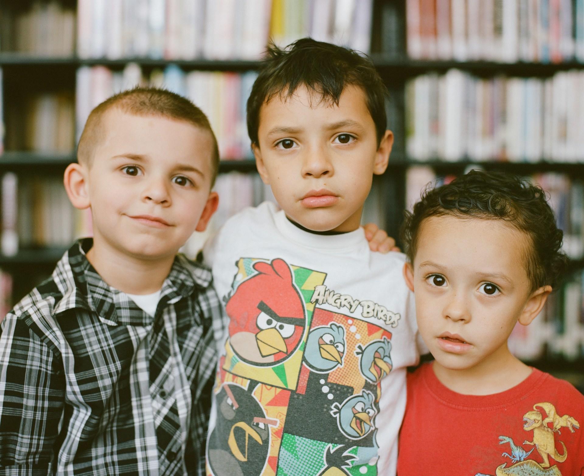 Three young boys in a library.