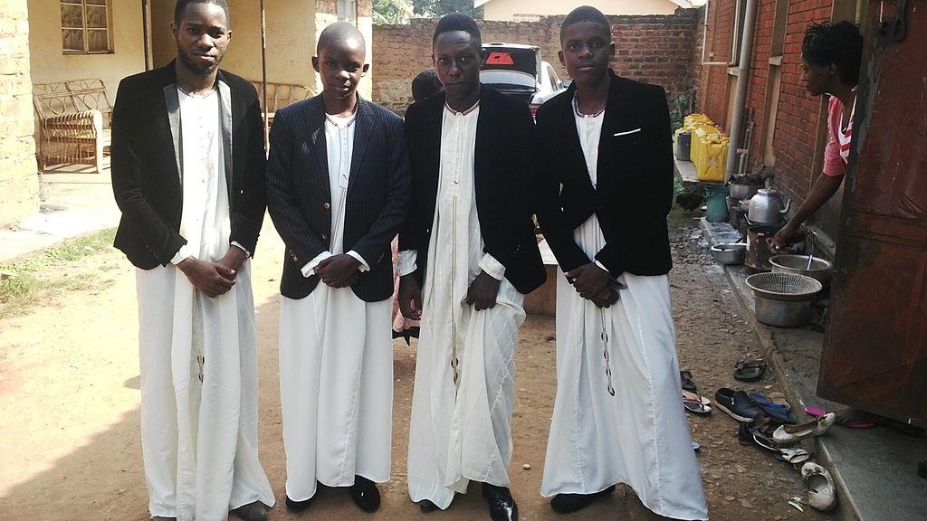 Four young men wearing a traditional Kanzu for a wedding.