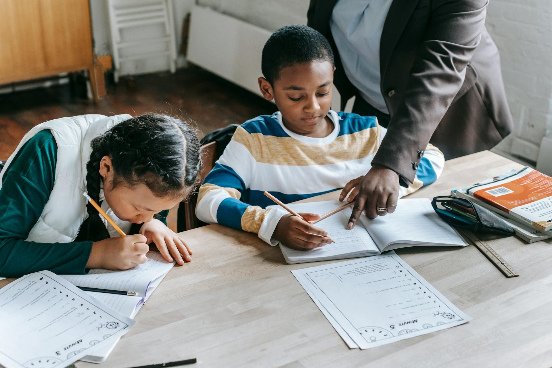 Young students getting help with math homework from a tutor