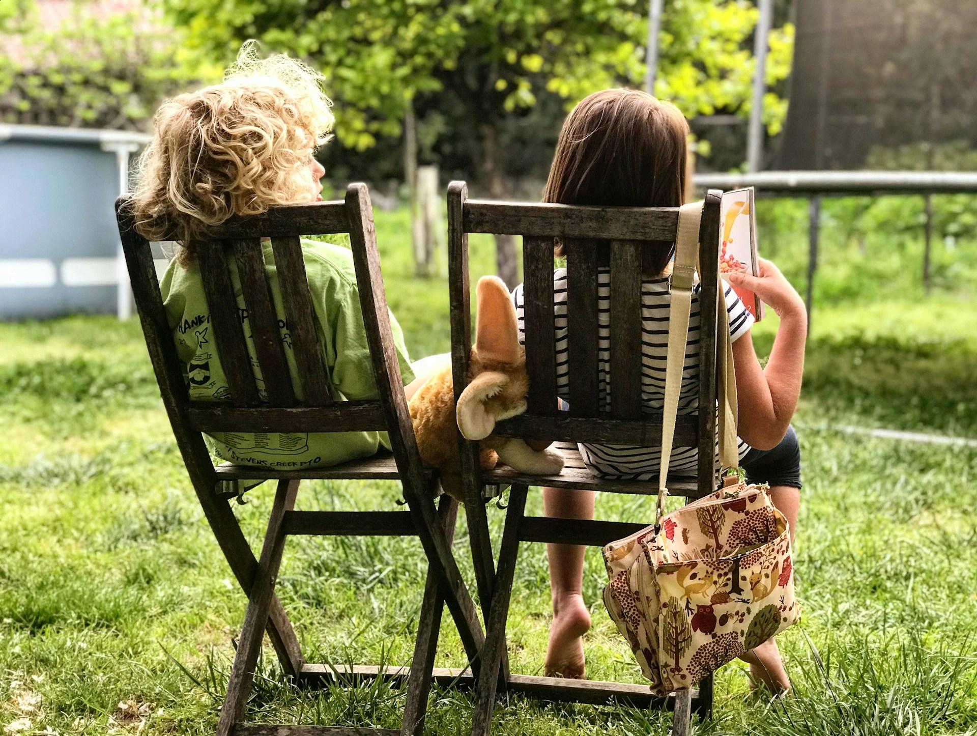 Two kids reading in the garden.