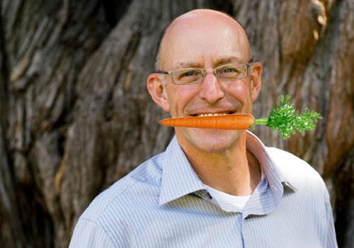 Michael Pollan with a carrot in his month
