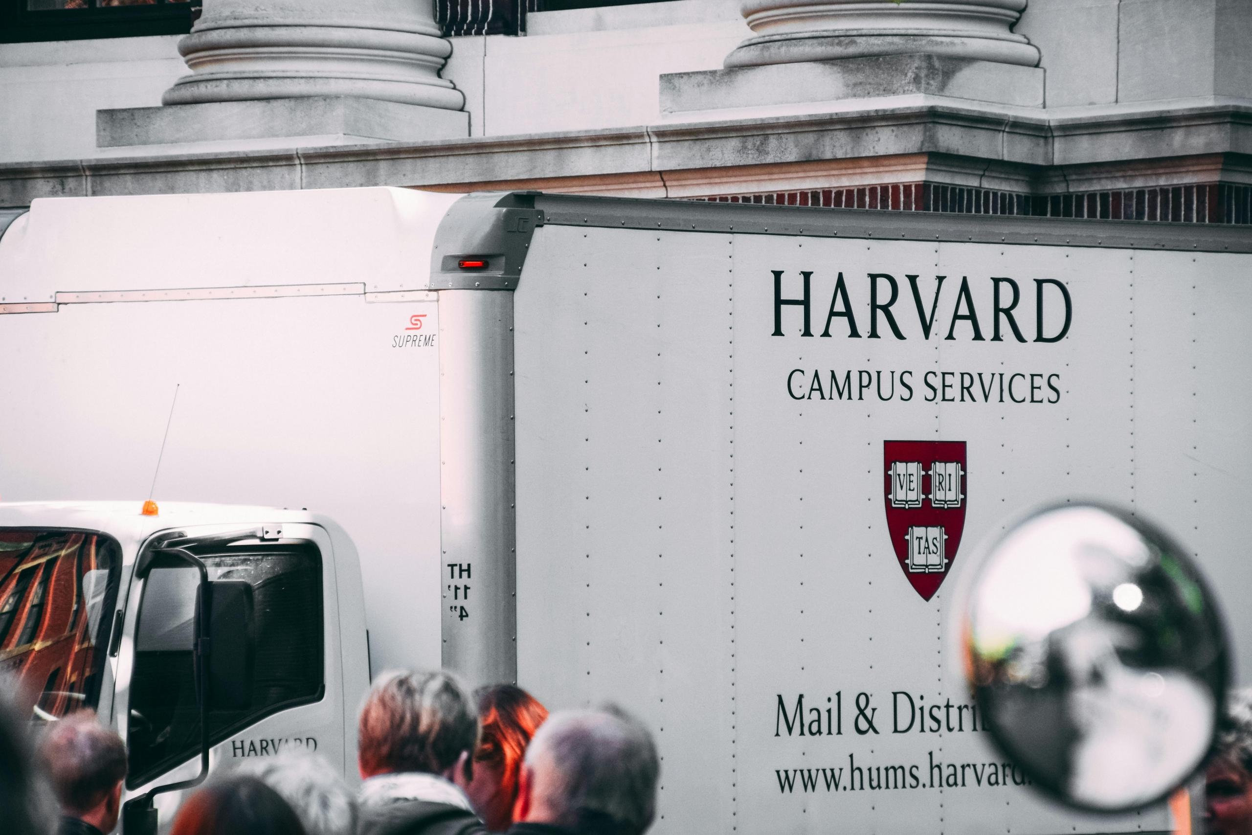 A white van driving theough the Harvard campus with Campus services written across the side of  it.