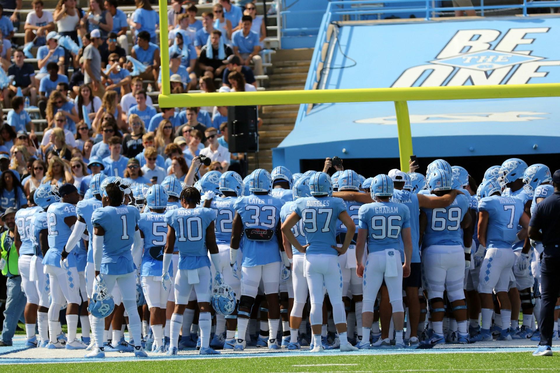 UNC Tar Heels football team gathers on the field before a game