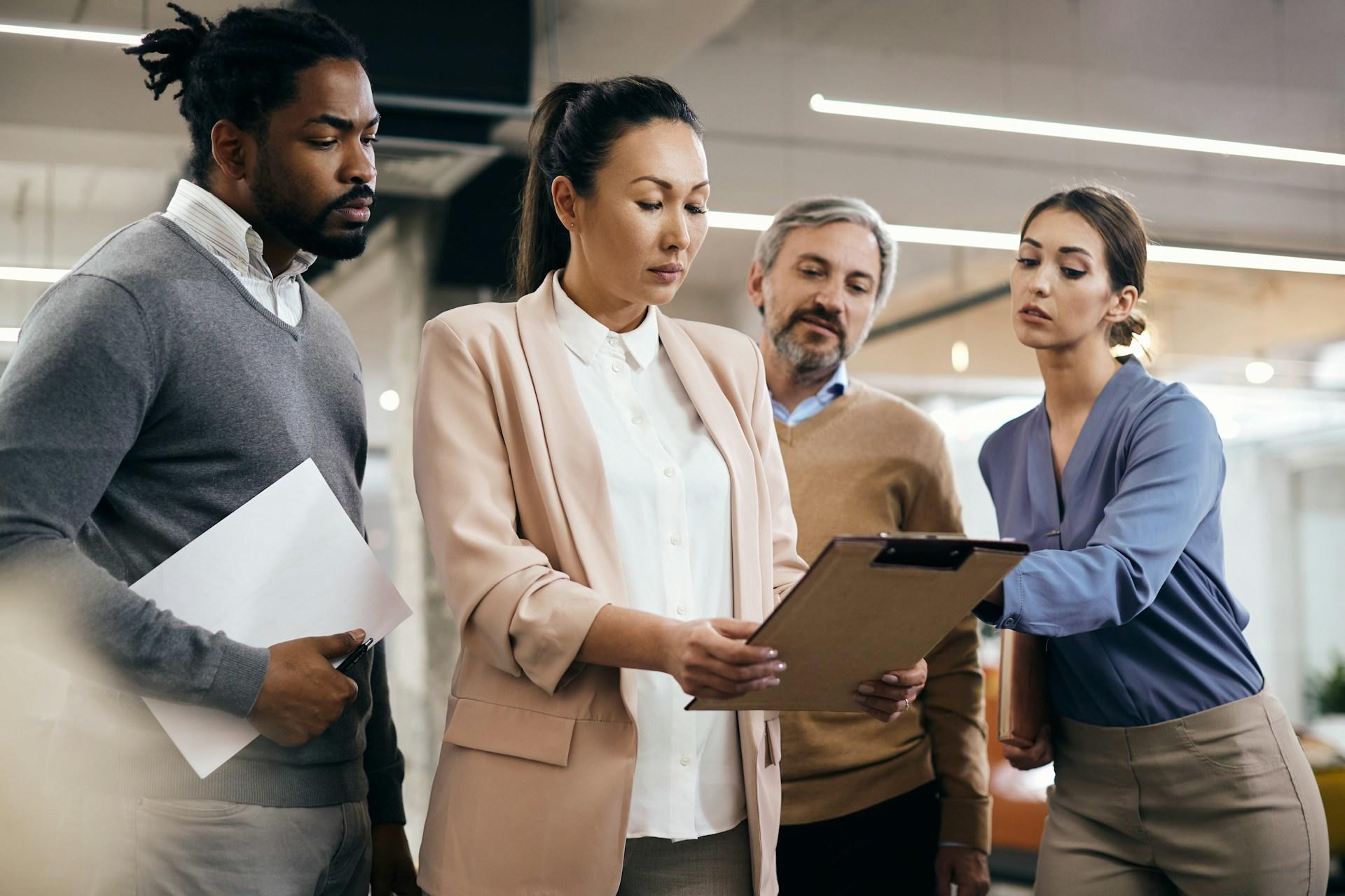A leader showing her notes to a group of peers.