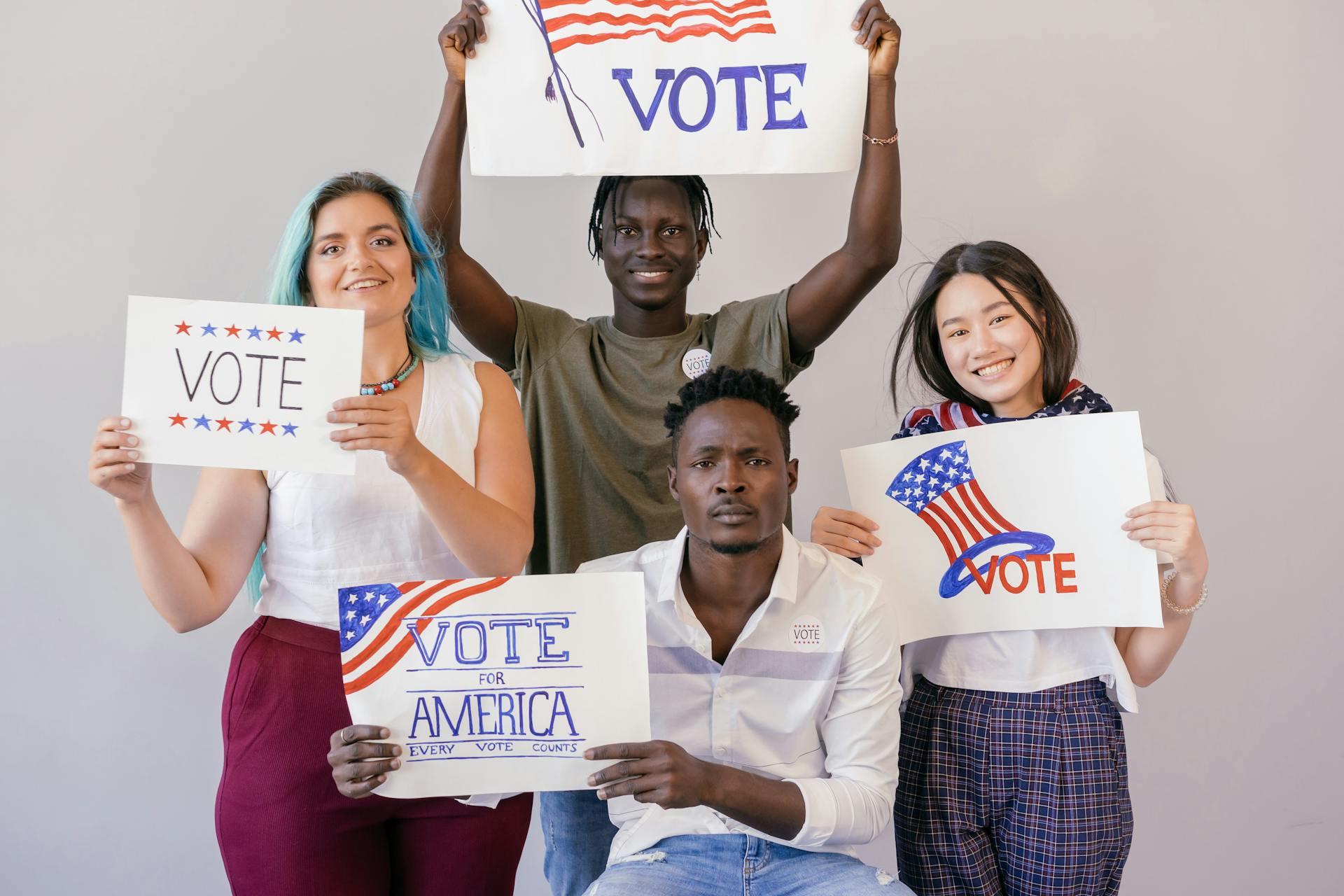 A group of diverse people holding signs about voting
