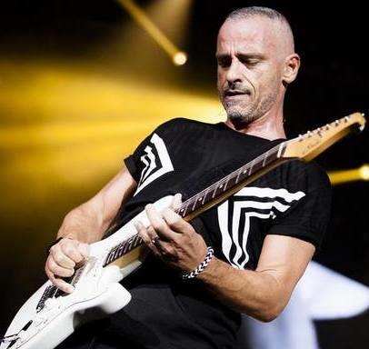 Eros Ramazzaotti playing the guitar on stage.
