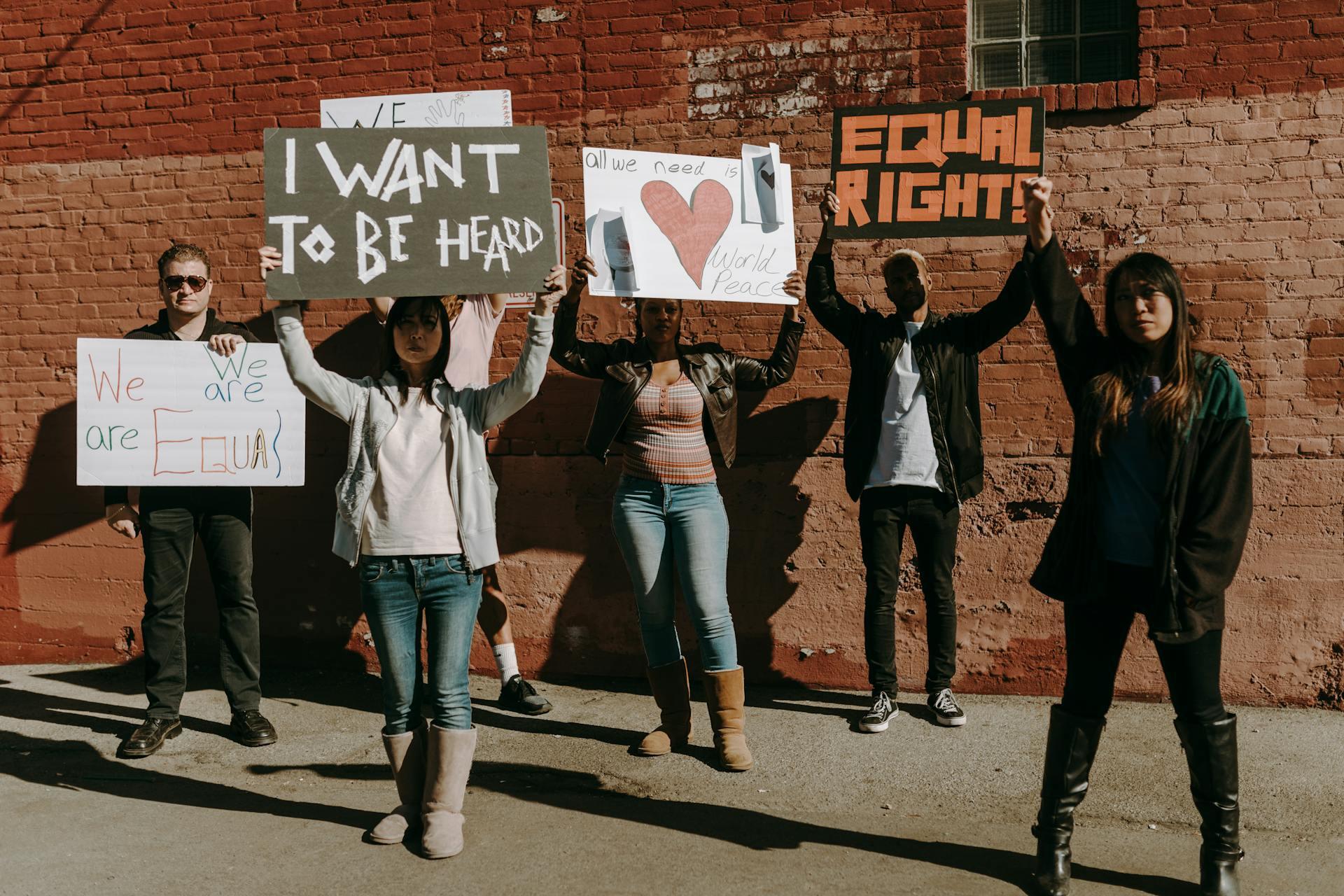 A group of people holding signs that say "equal rights" and "I want to be heard."
