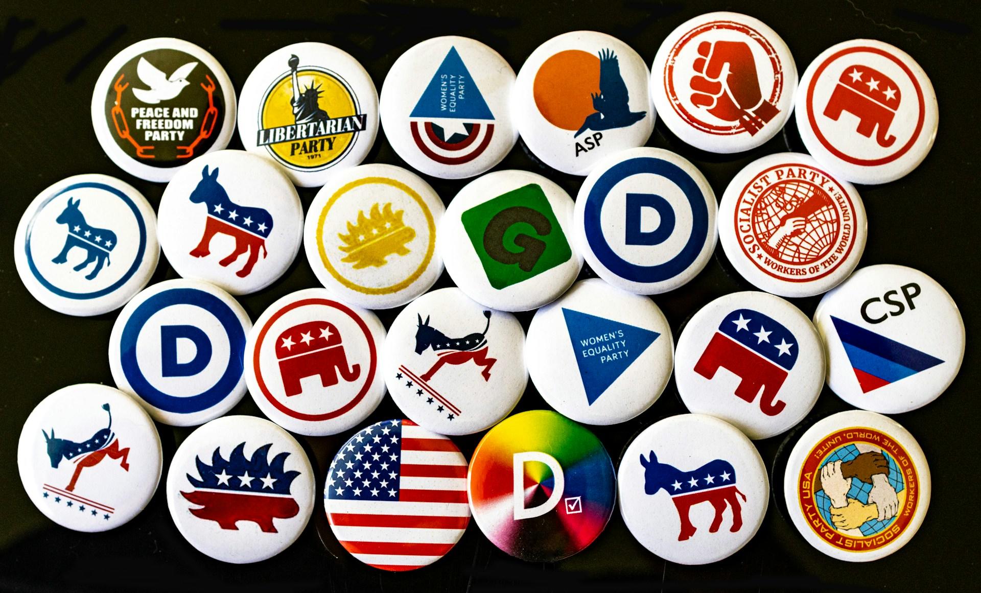 an assortment of pins with different political party logos on them