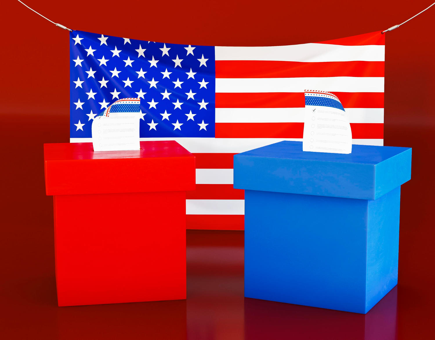A red box and a blue box, both with ballots sticking out the top, in front of an American flag