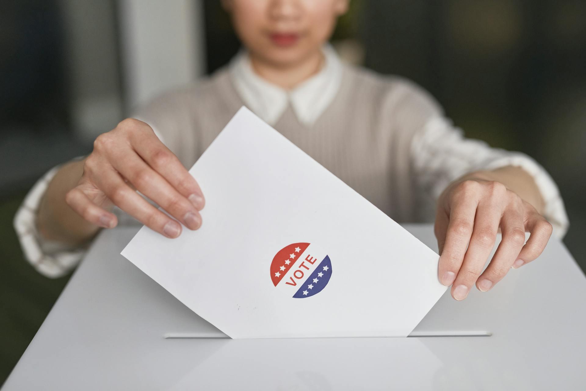 A voter putting a ballot in a box