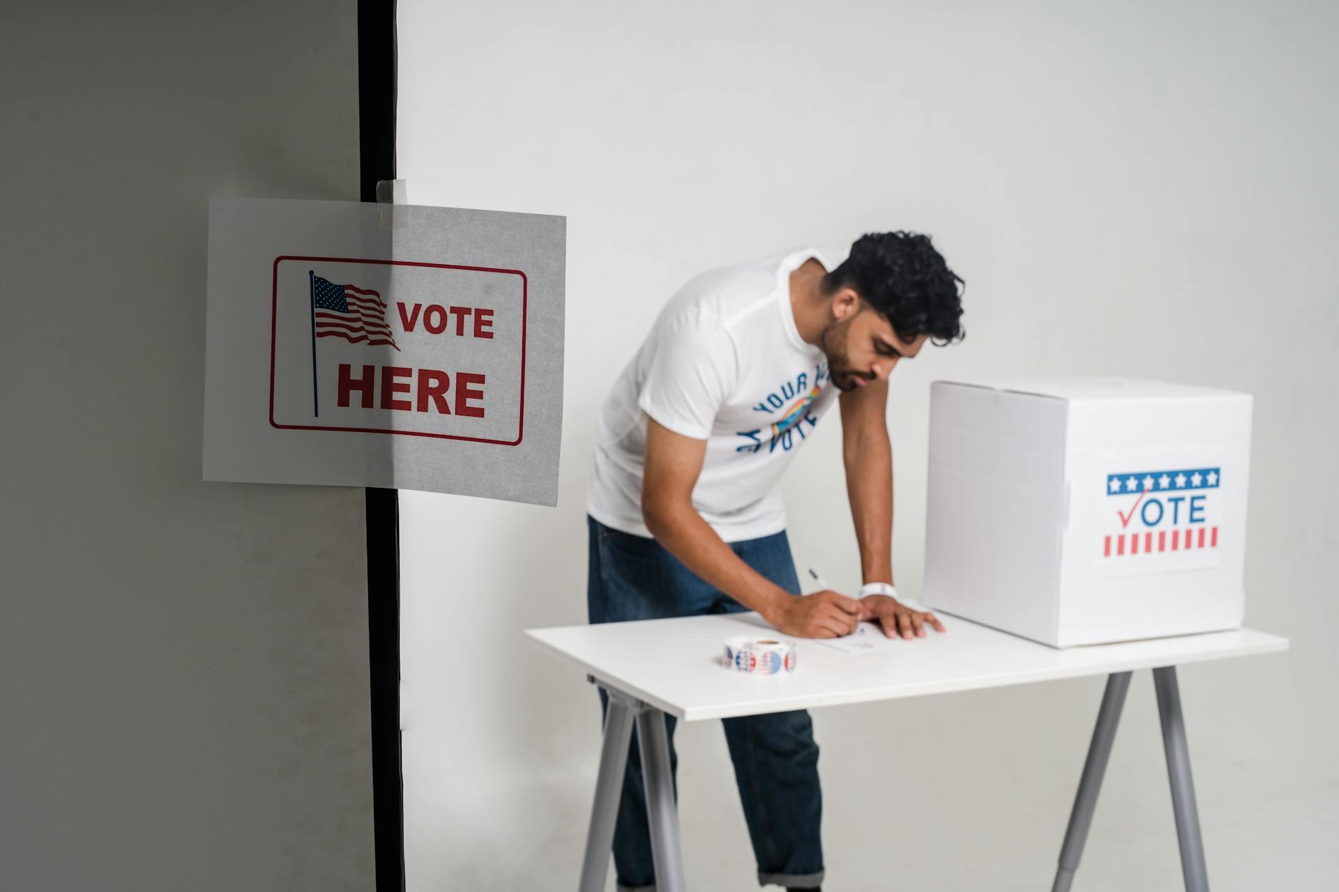 A voter using a voting booth to fill out a ballot