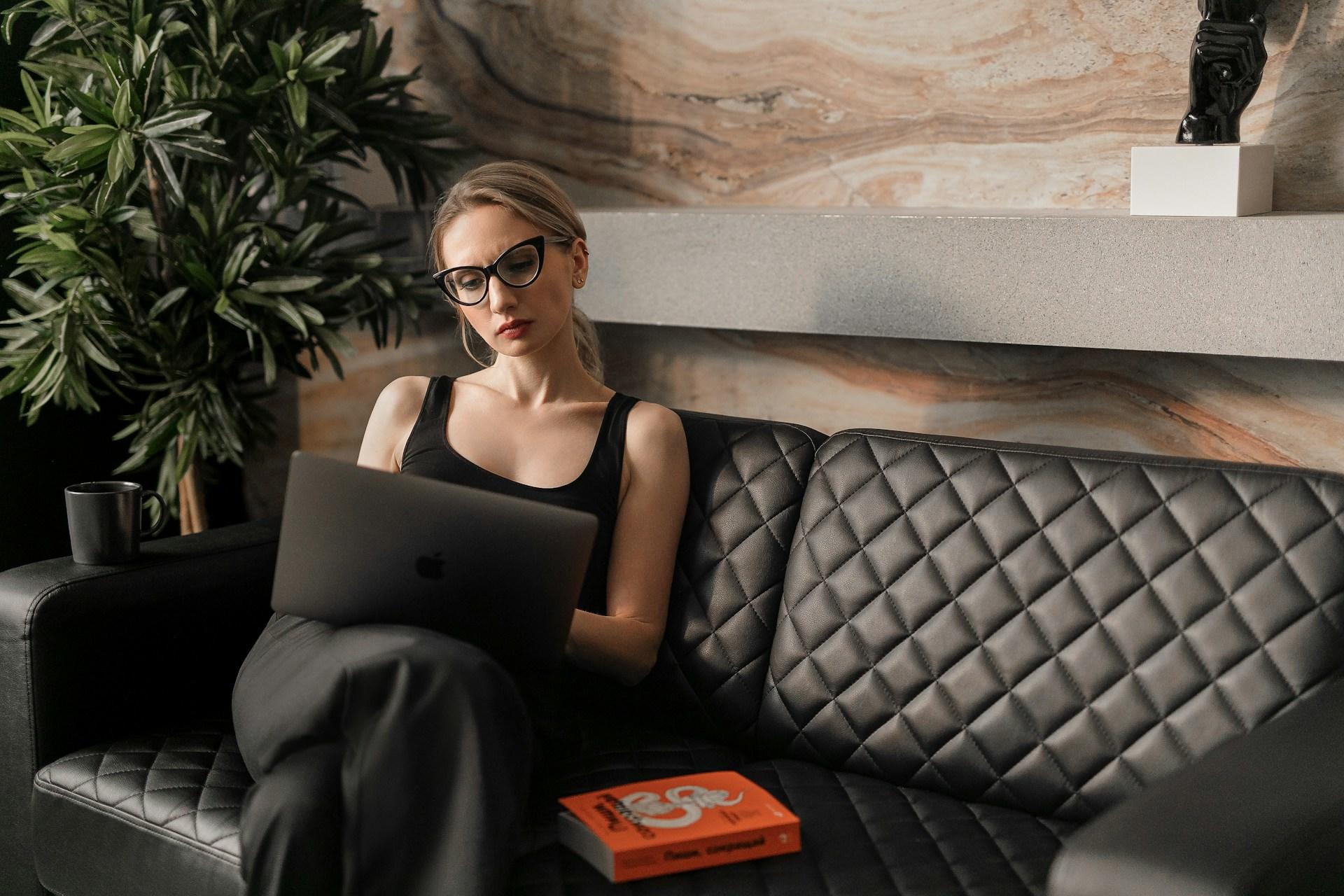 A women sitting on the couch using her computer.