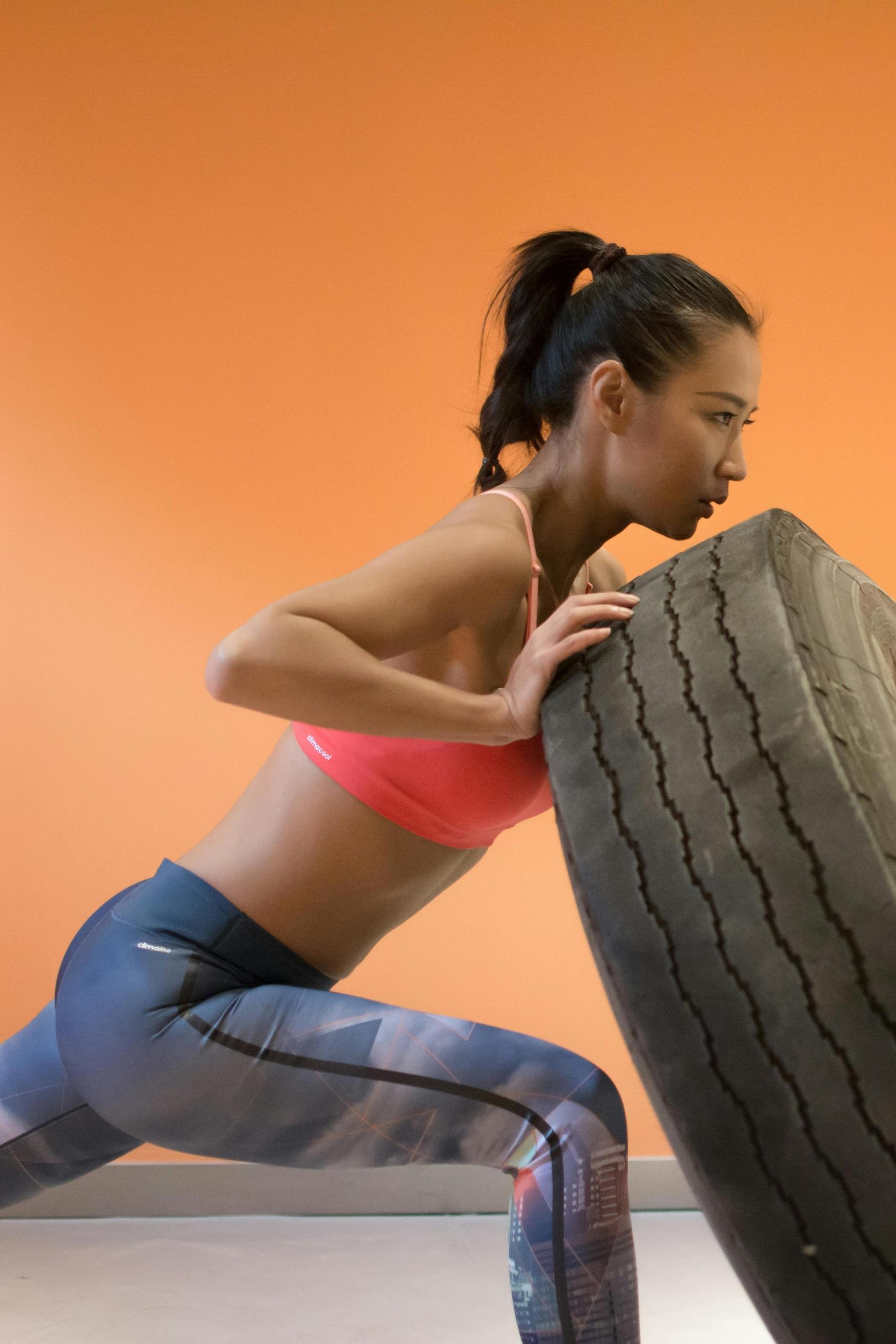 A woman flipping a tire to build up her strength and cardio