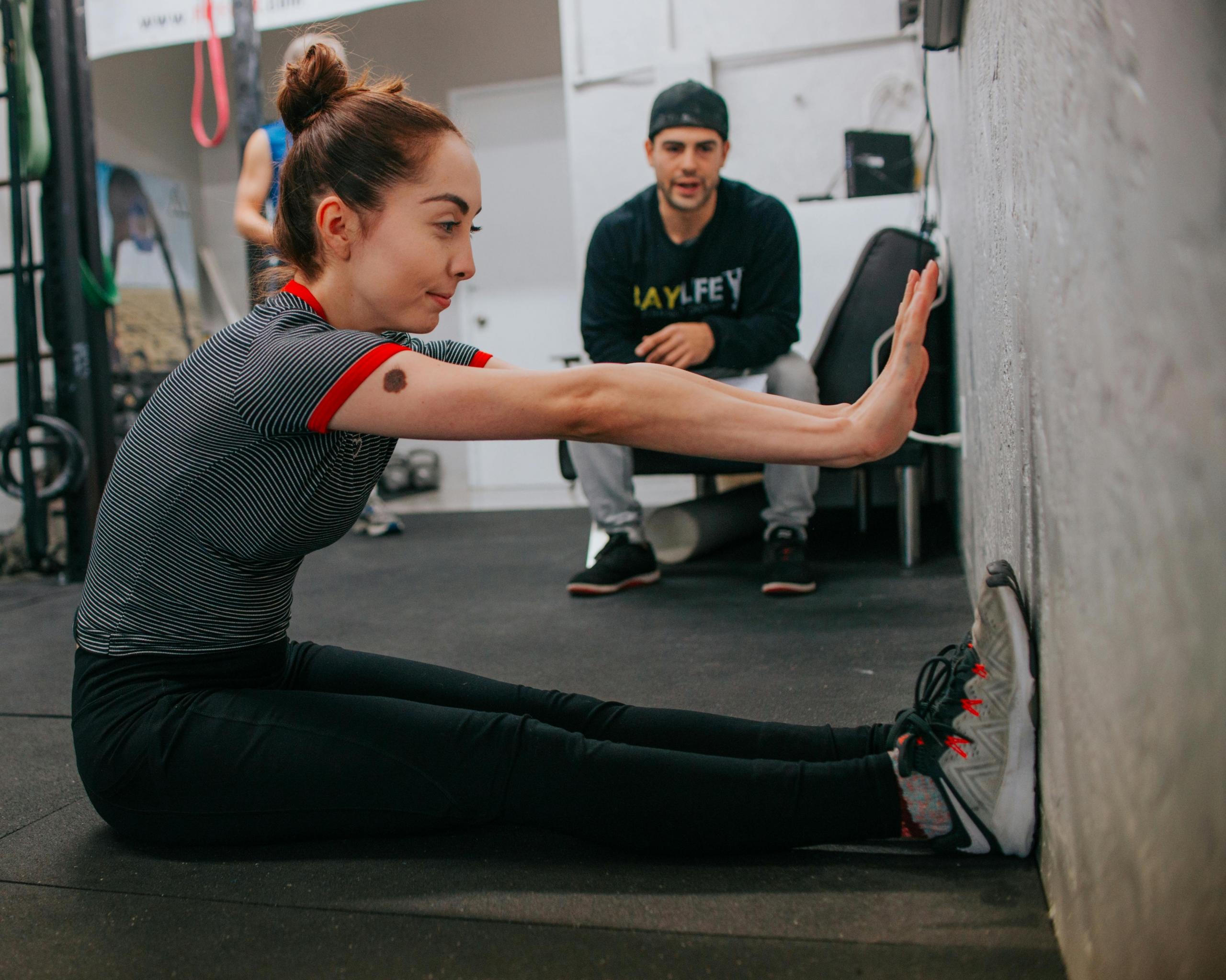 A personal trainer watches over one of his clients during a private session.