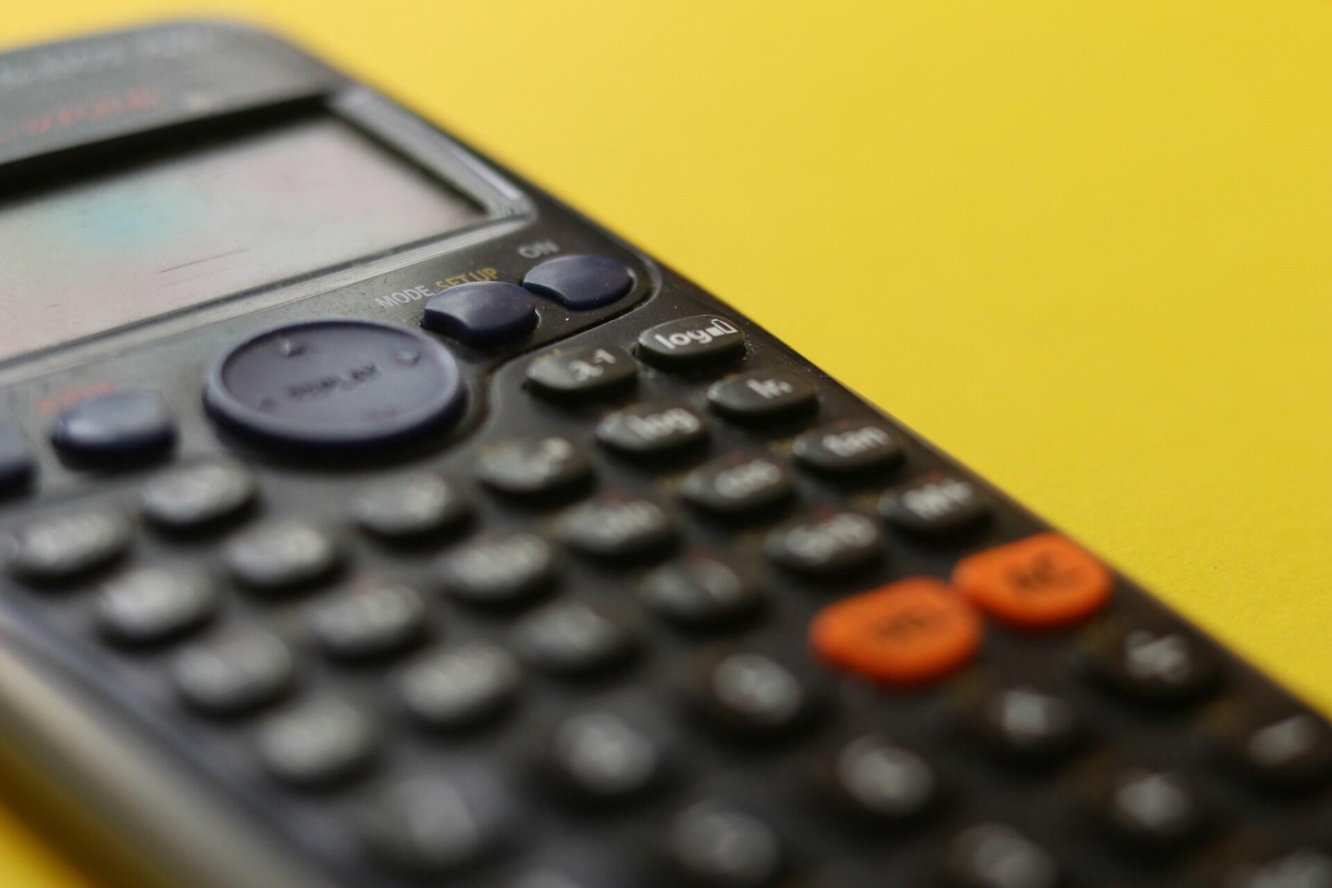 A scientific calculator on a yellow background.