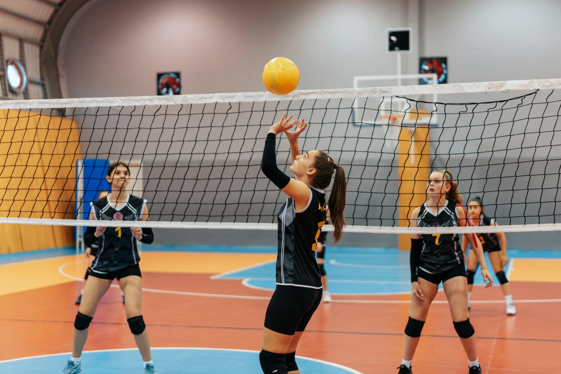 Four volleyball players playing a match.