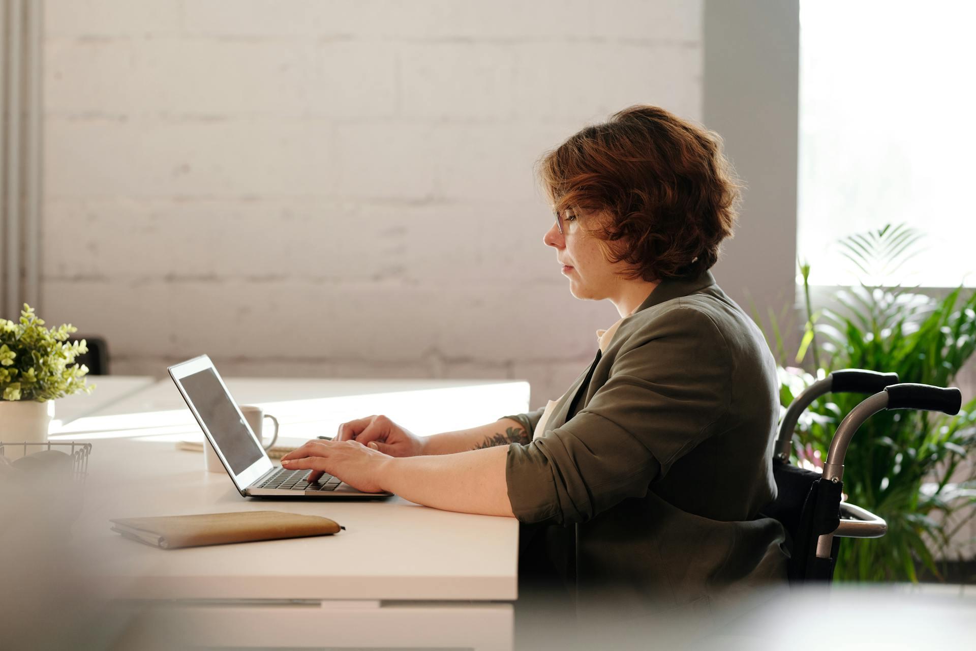 A lady sitting on at her desk with her computer.