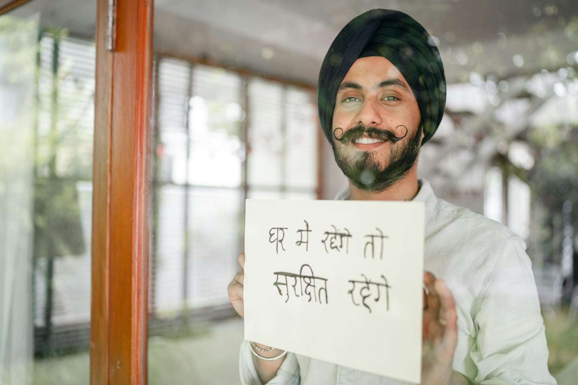 A man holds up a sign in Hindi.