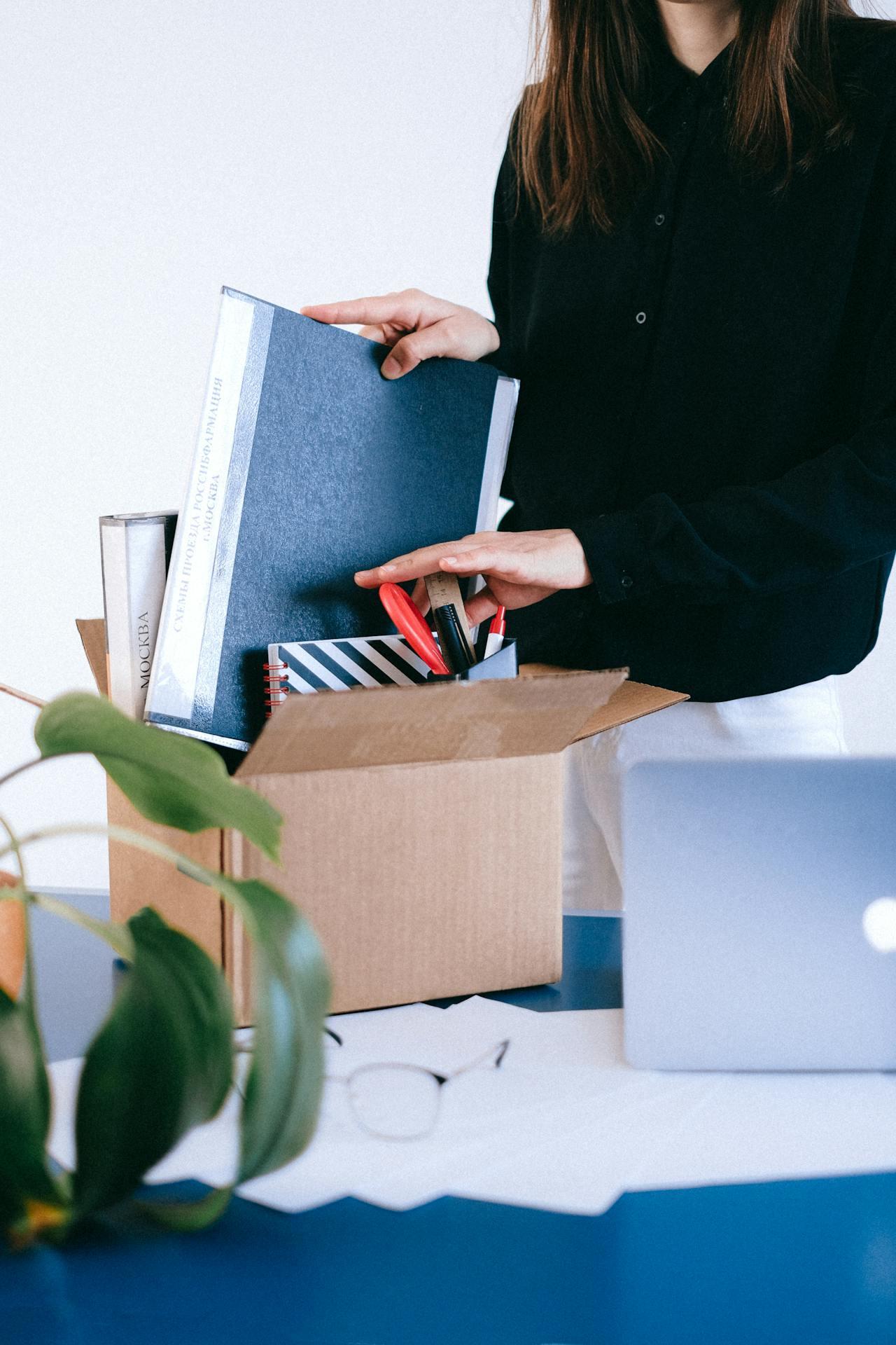 A woman packs up her belongings leaving her job.