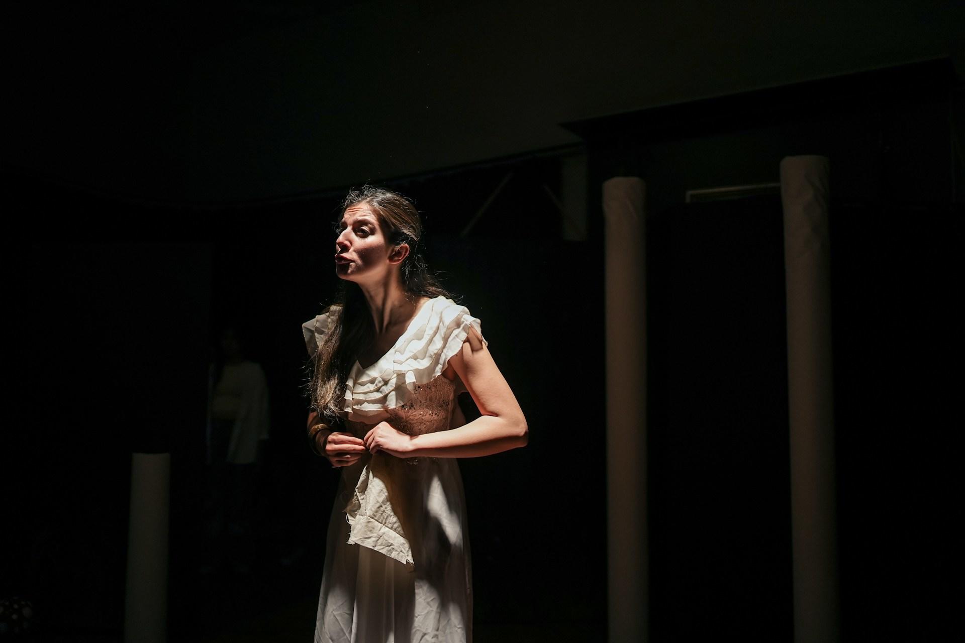 An actress delivering a monologue alone on stage.
