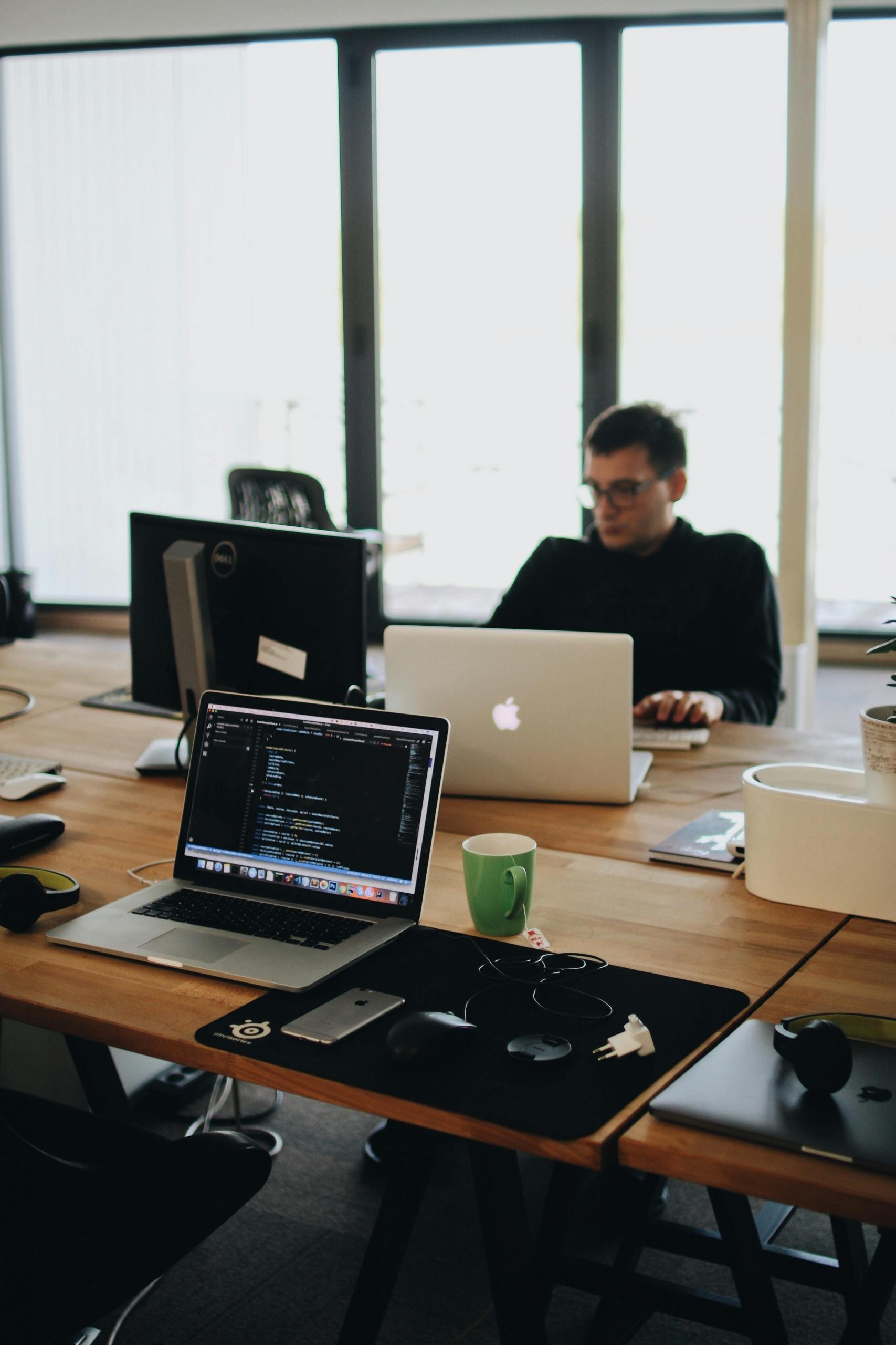 A man in a black shirt focused on programming