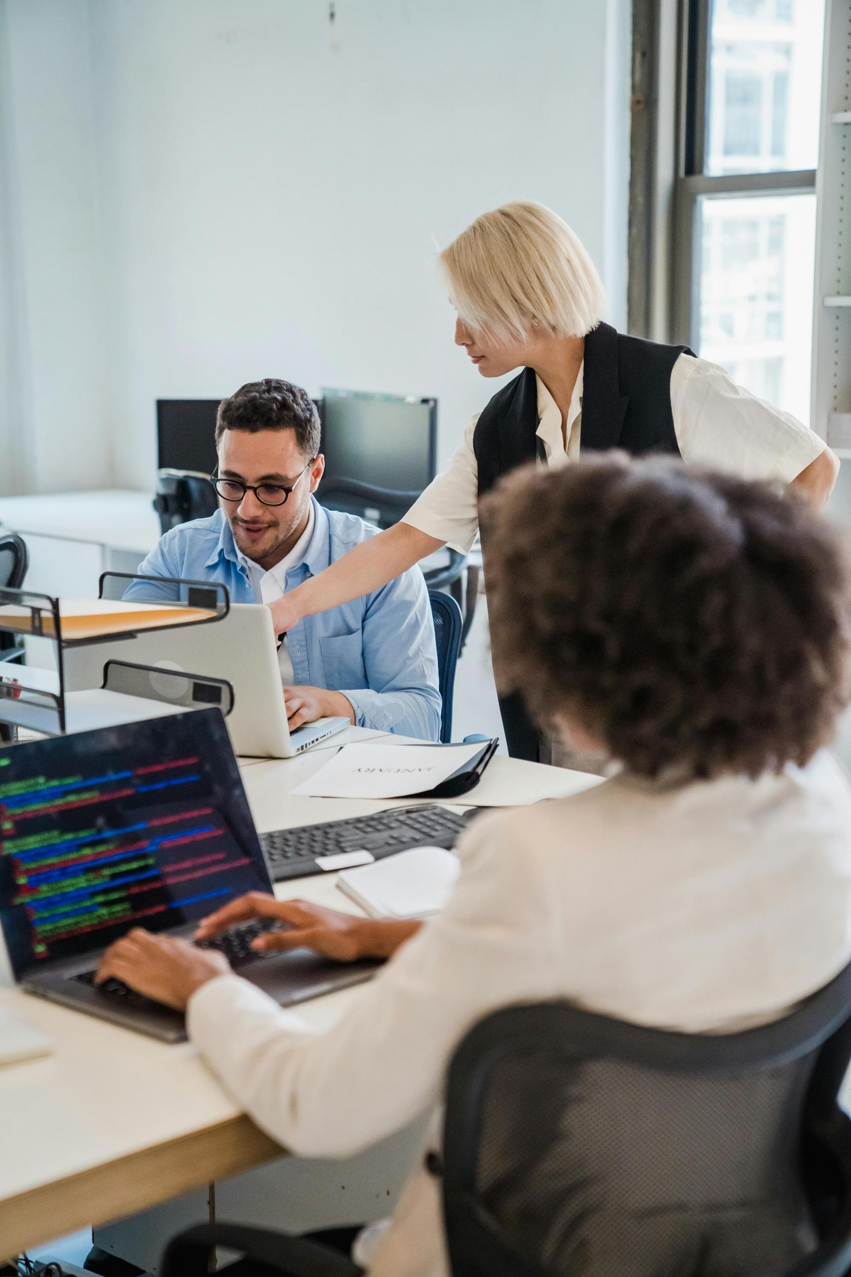 A group of programmers collaborating in an office space, working together on coding projects