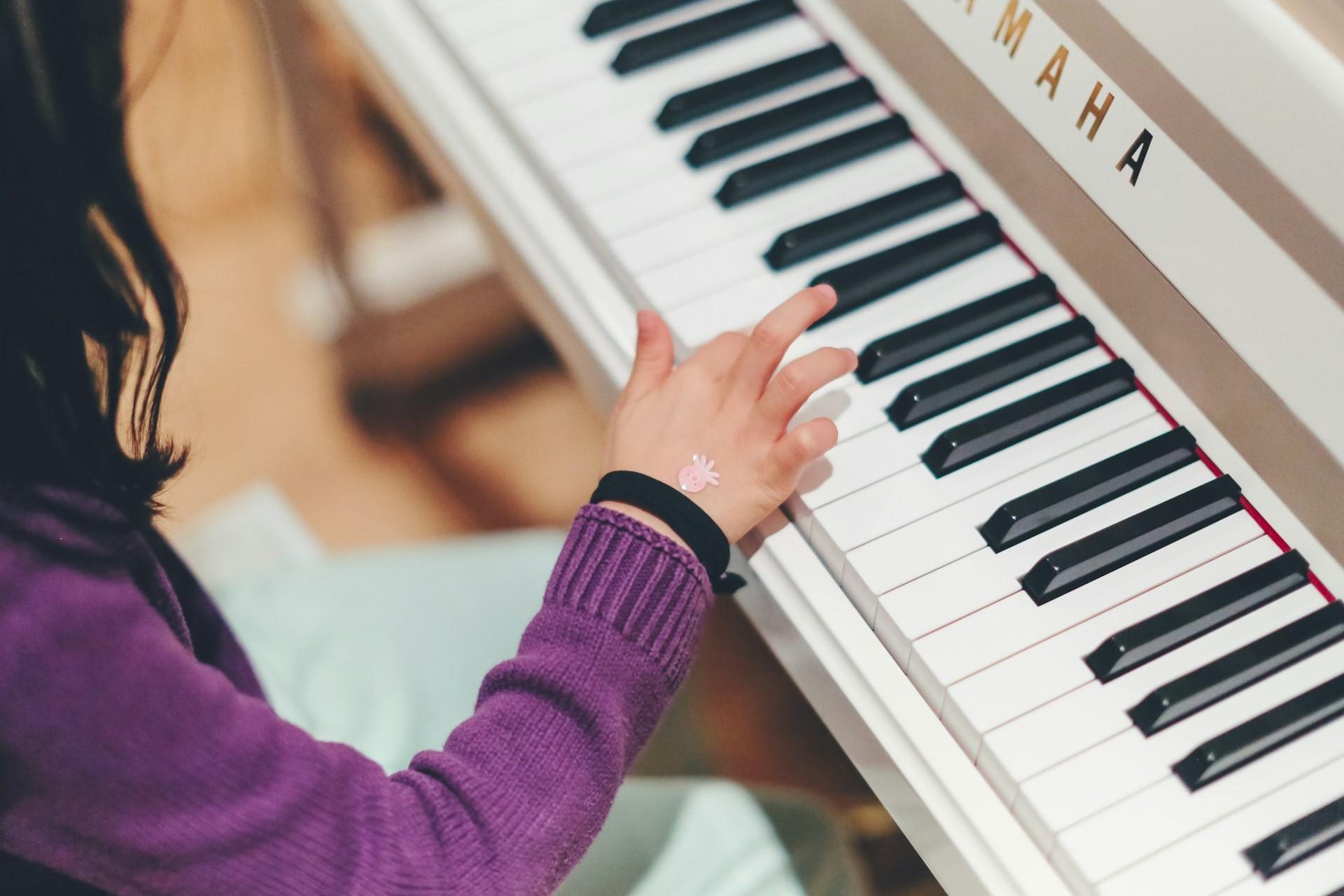 A girl playing a Yamaha piano.