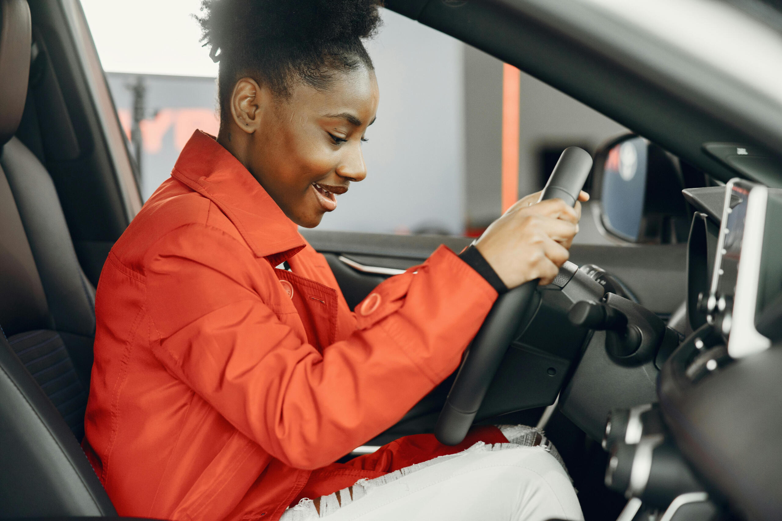 A young woman behind the steering wheel of a car