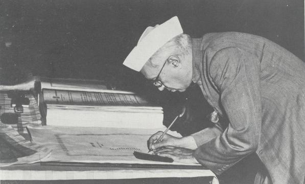 Jawaharlal Nehru signing the constitution of India.