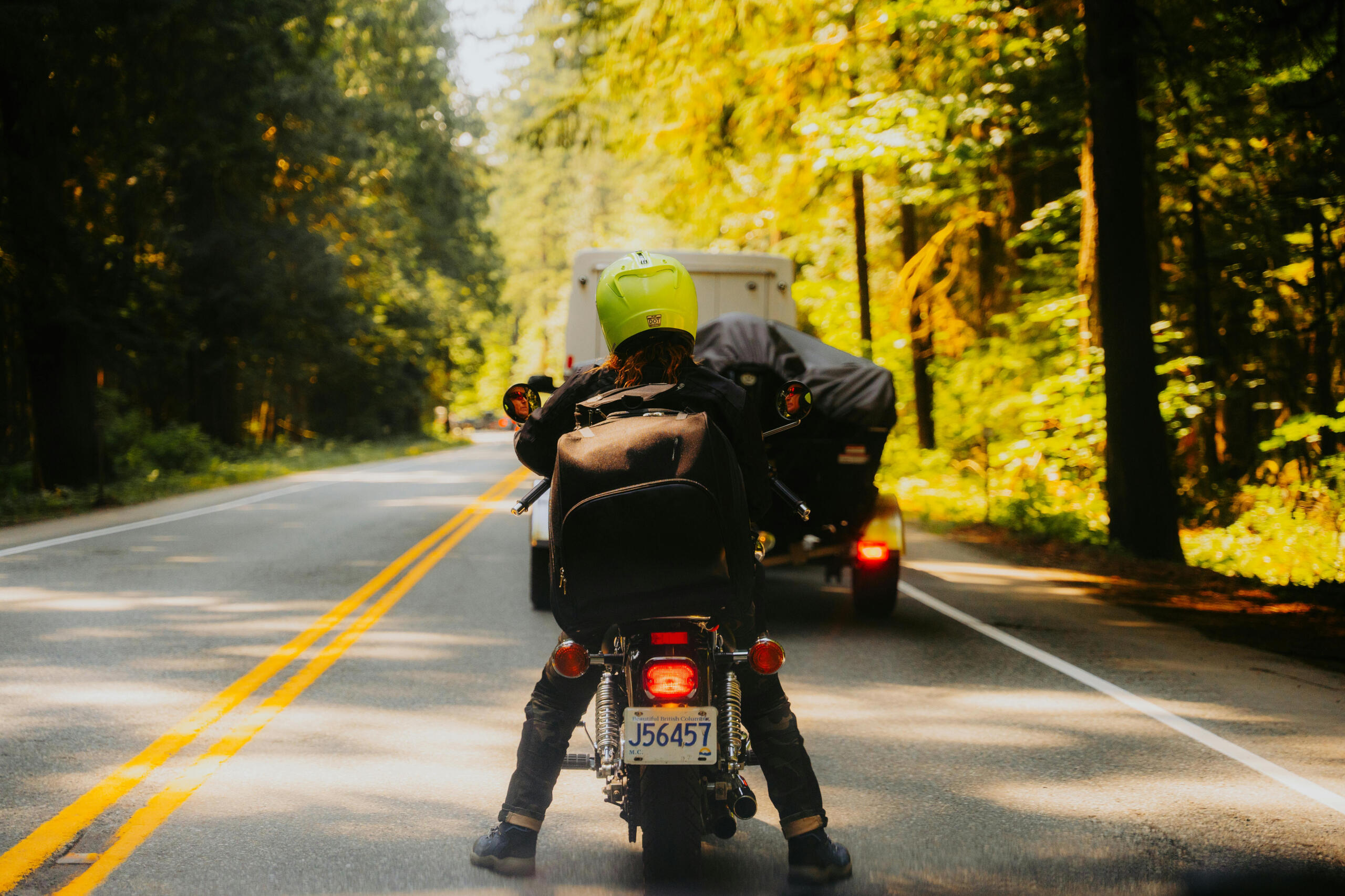 Motorcycle waiting in traffic on a road in the forest.