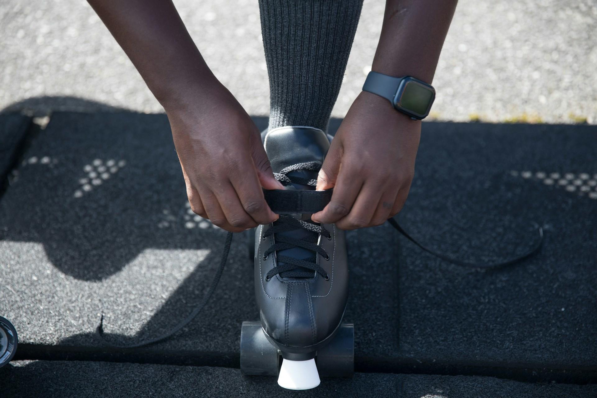 Someone fastening the strap on their roller skate.