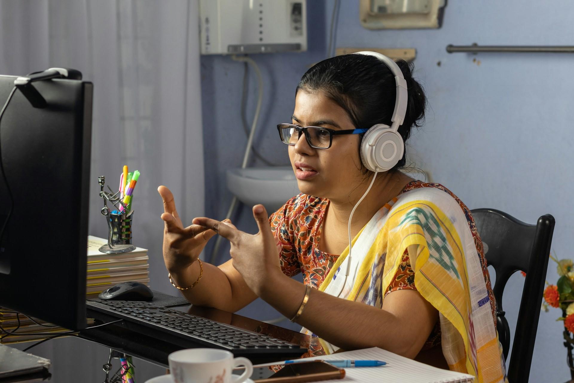 A young girl practicing sign language via a webcam.