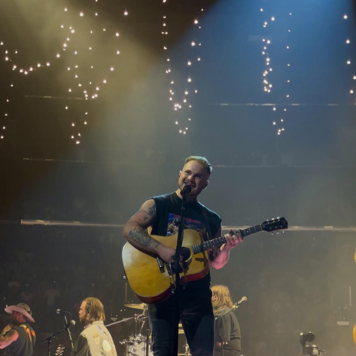 Photo of Zach Bryan performing on stage