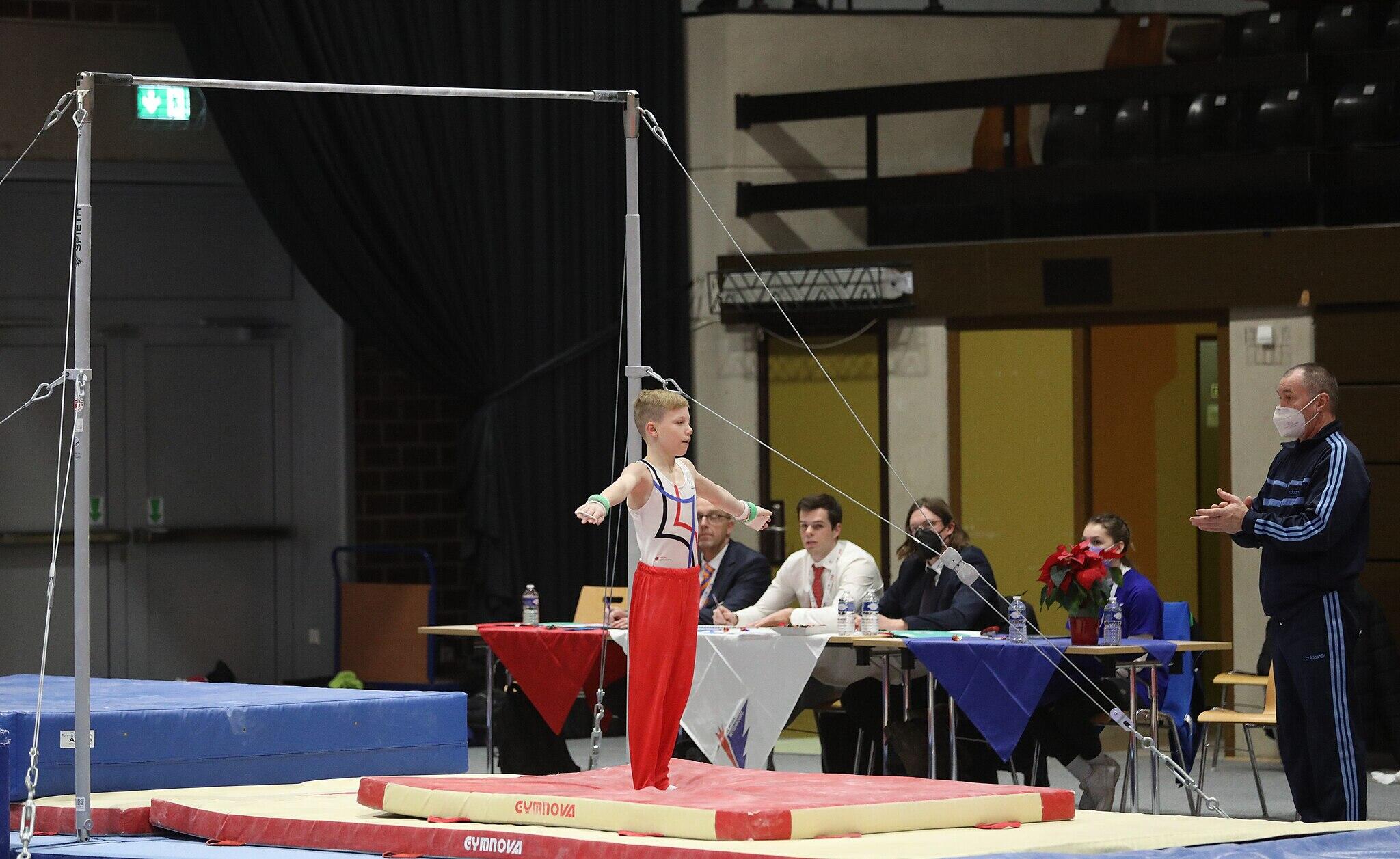 Little boy during horizontal bar event.