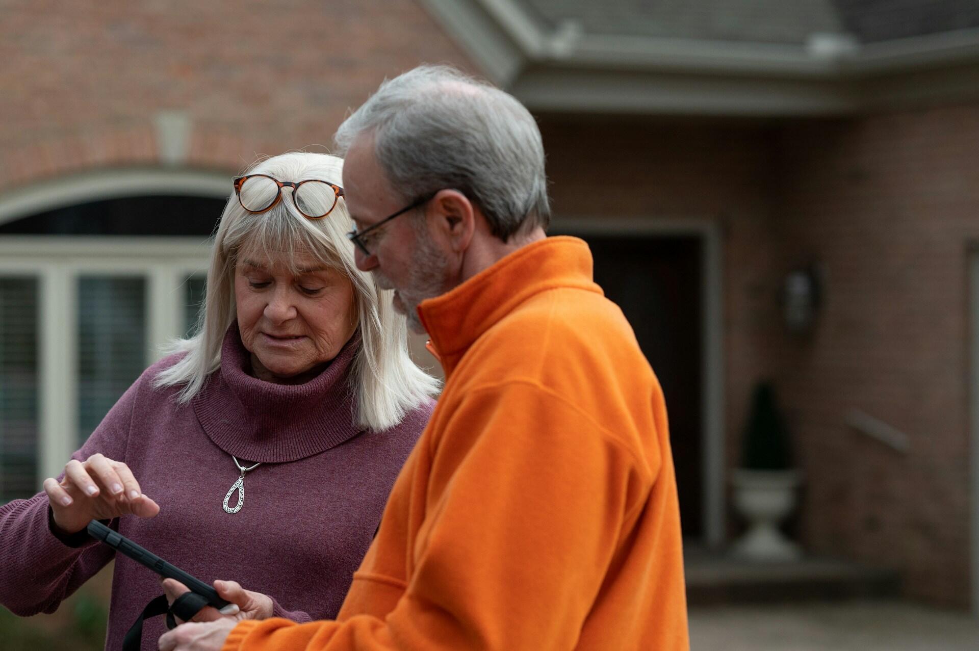 An elderly man asking a women for directions.