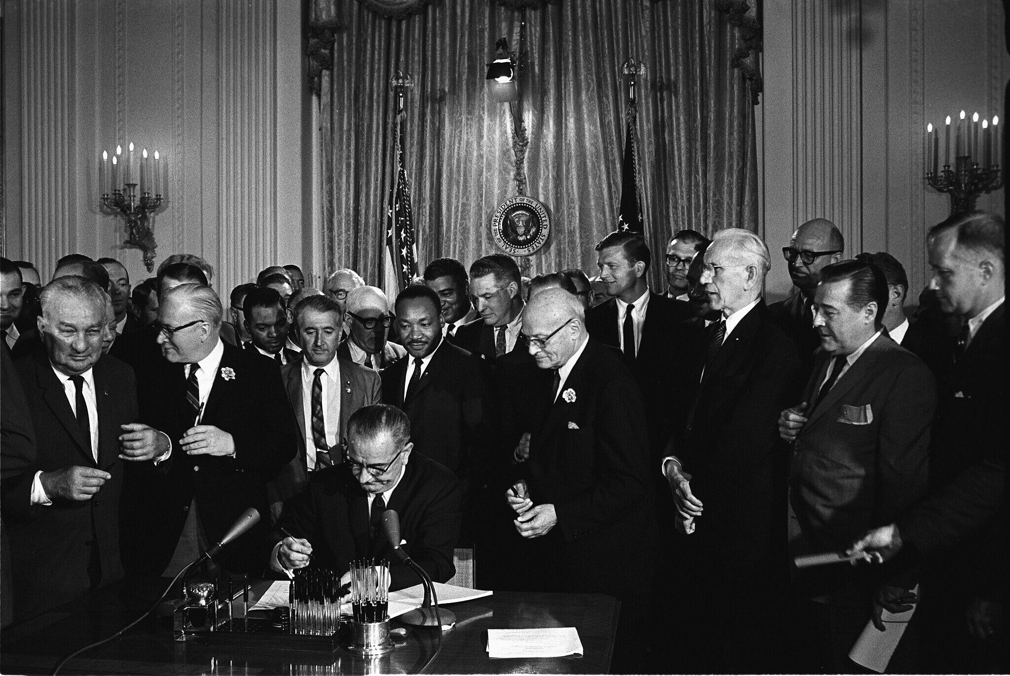 President LBJ signing the Civil Rights Act of 1964 in the White House with an audience