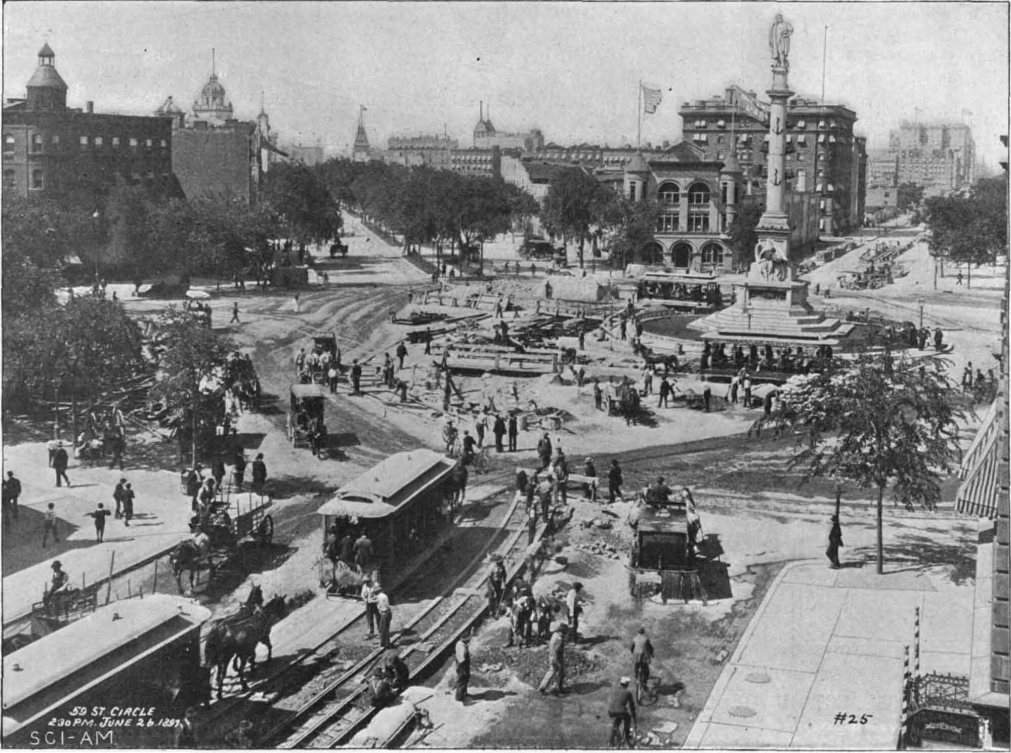 A black and white photo of a street in NYC in 1897 where horses and horse-drawn trolleys can be seen.