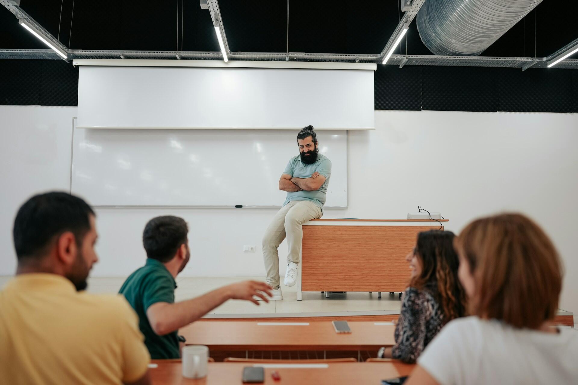 A tutor at his desk with four students sitting in front of him.