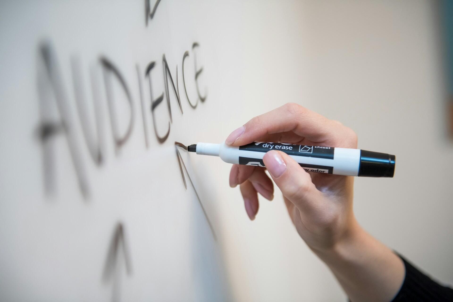 A person writing on a whiteboard.