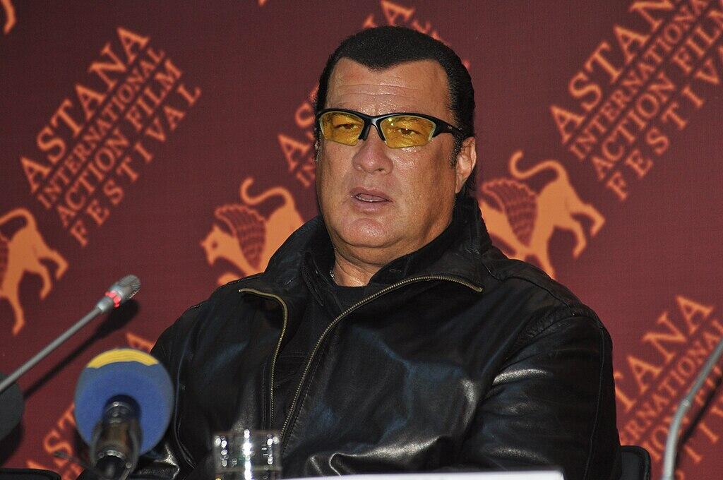 Steven Seagal with sunglasses on during a speaking panel.