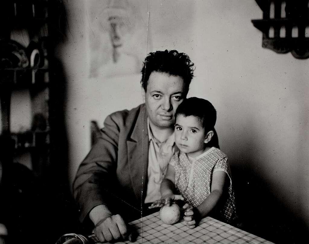 Diego Rivera and his daughter sitting at a table.