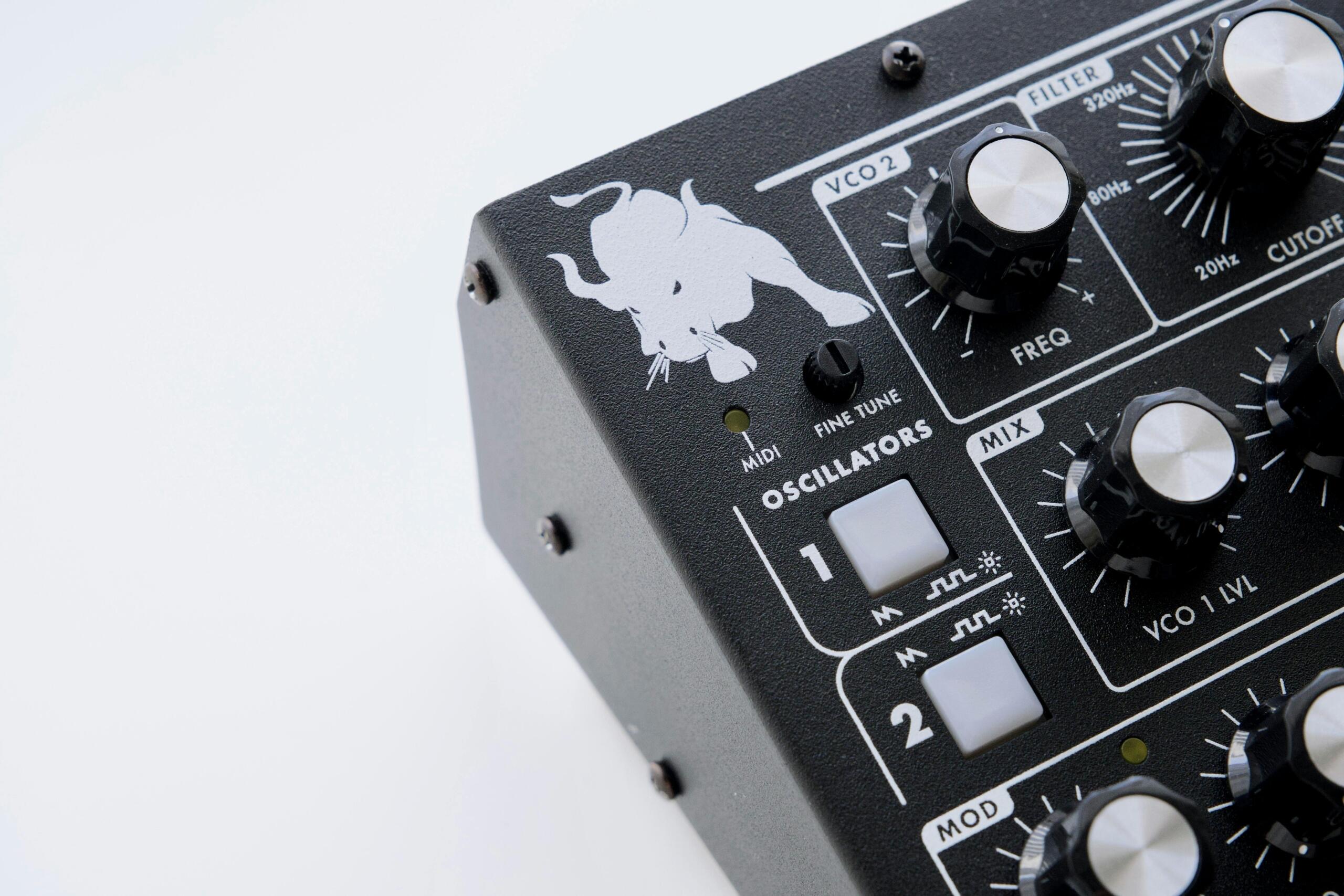 Close-up of the Minitaur Analog Bass Synthesizer logo on a black surface.