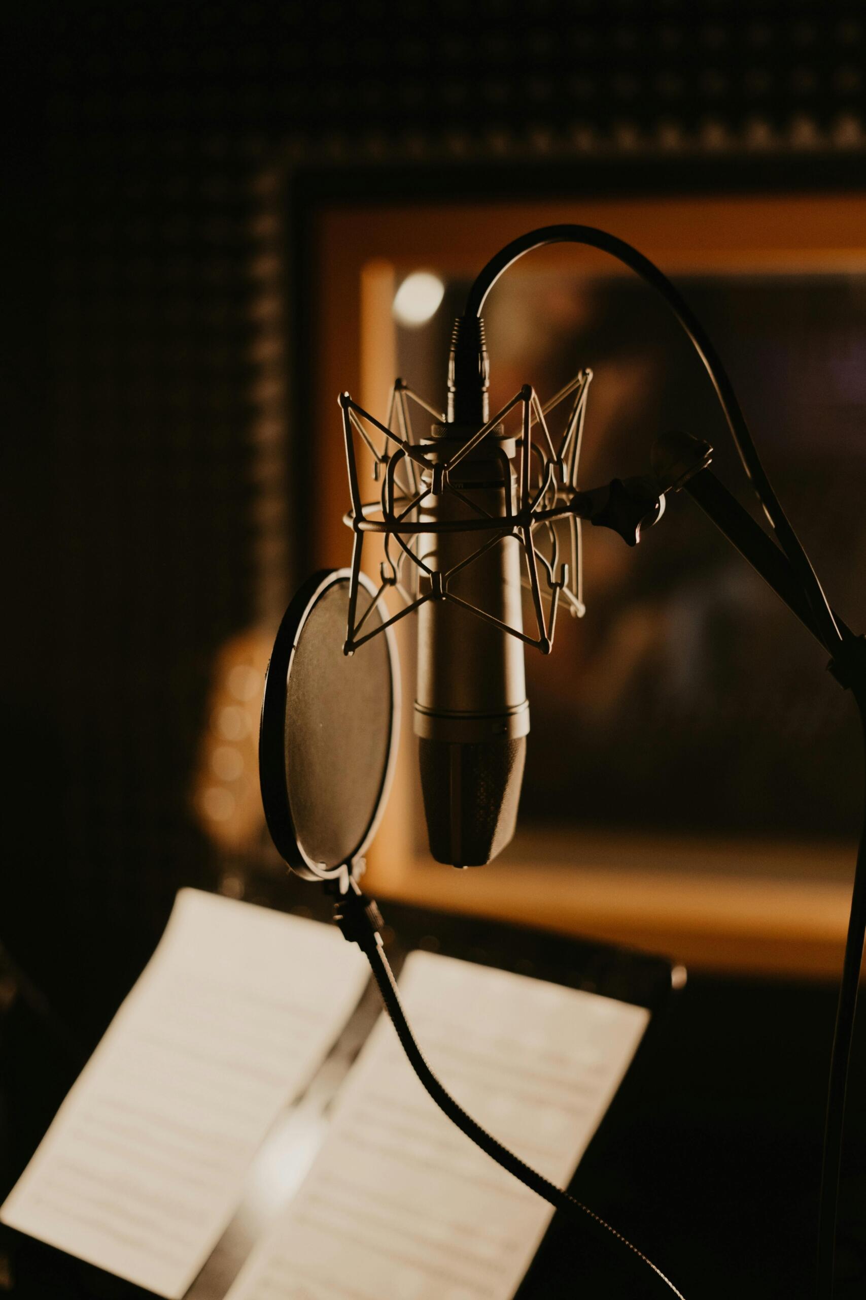Microphones set up inside a professional recording studio, positioned for vocal and instrumental recording.
