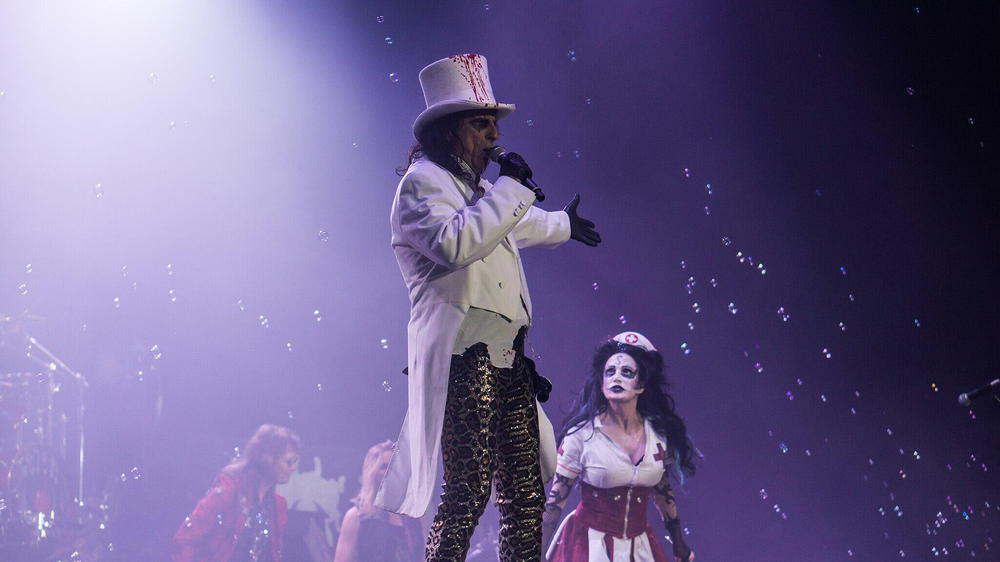 Alice Cooper performing on stage wearing a signature dramatic costume