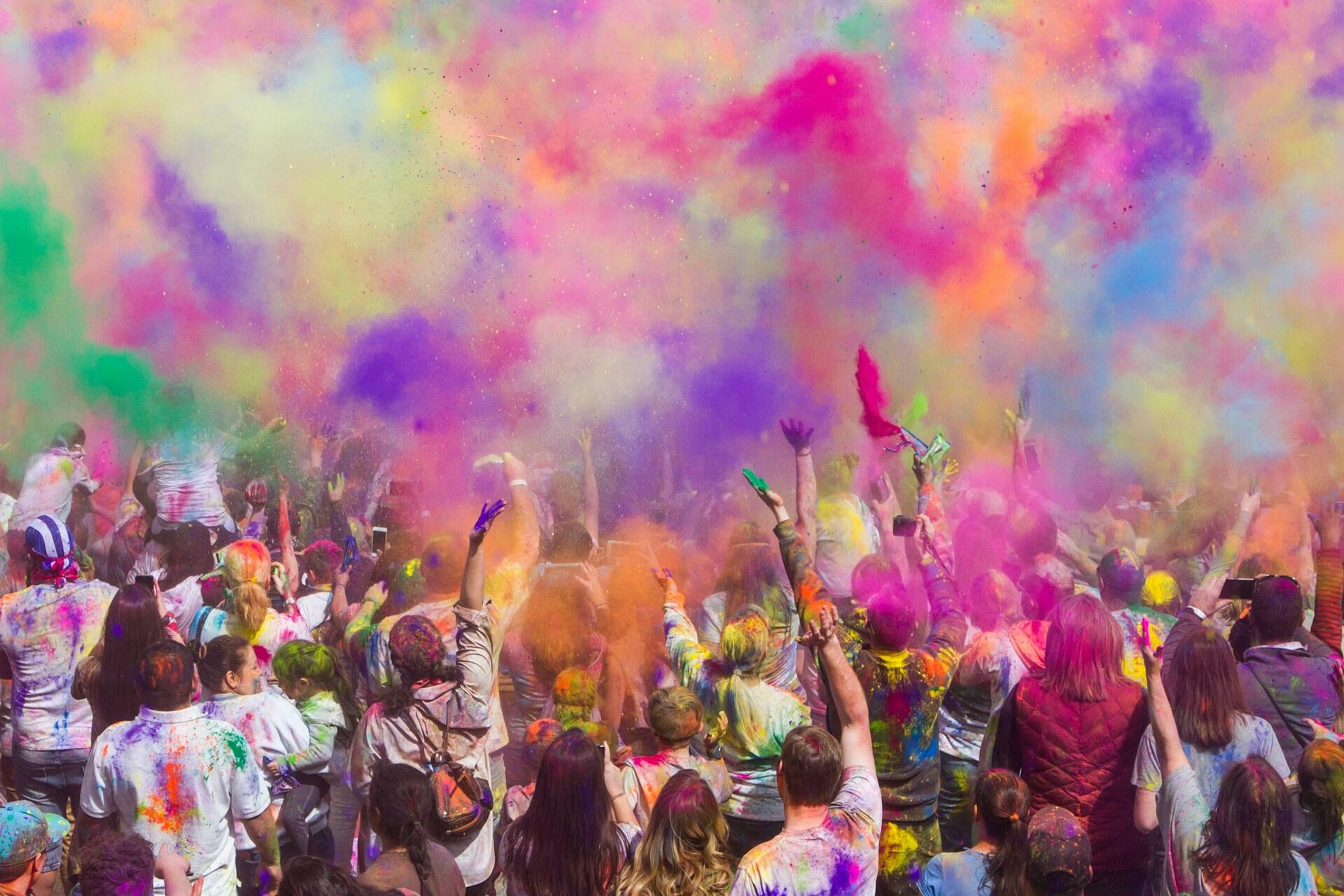 People throwing colored powders in the air for the Holi festival.