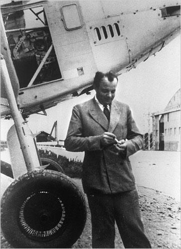 Antoine de Saint-Exupery infront of an airplane.