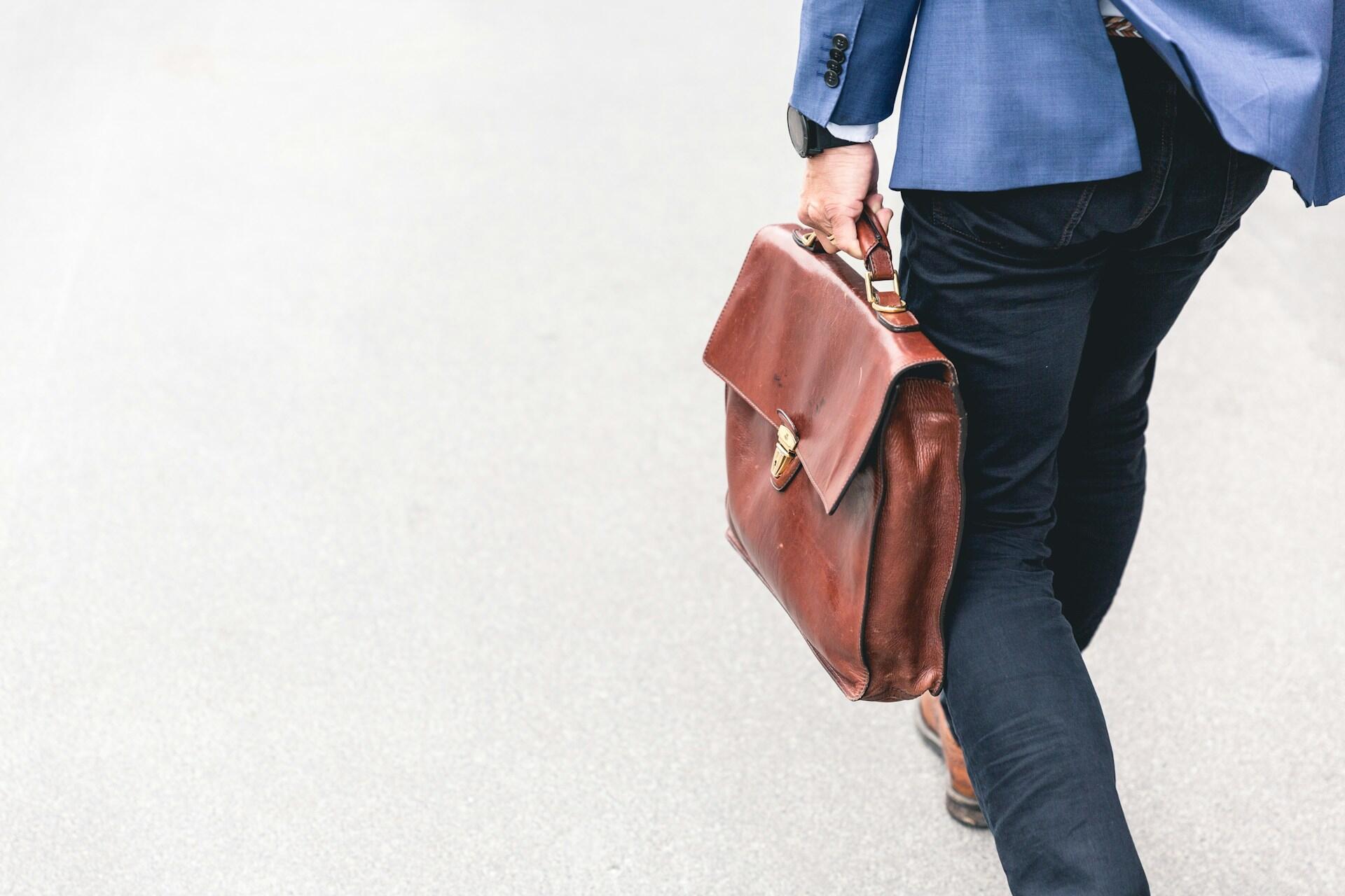 A businessman carrying a briefcase or satchel.